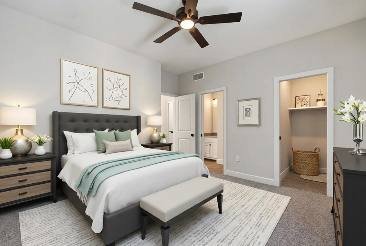 Carpeted bedroom featuring ceiling fan and ensuite bath