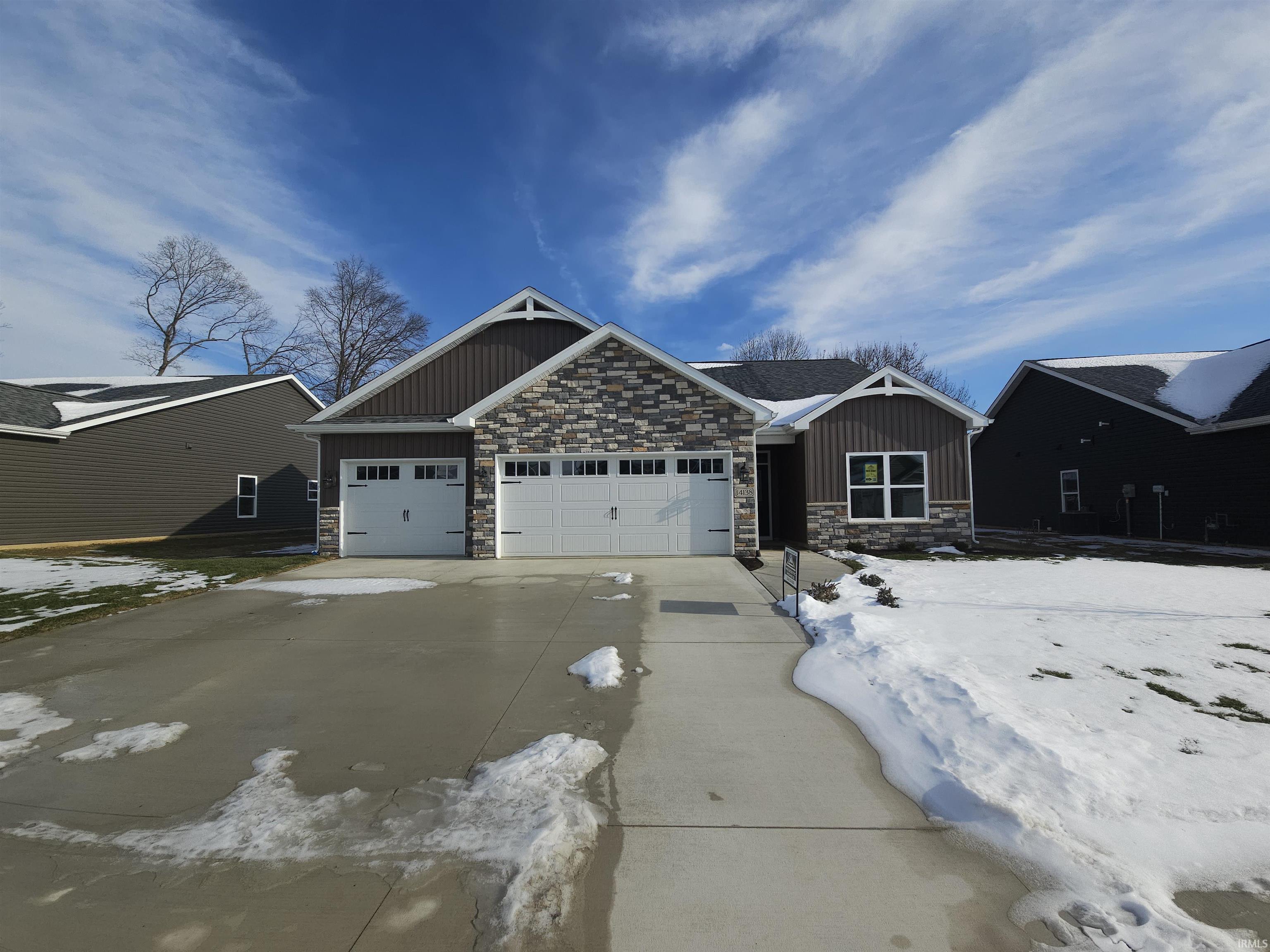 Craftsman inspired home featuring board and batten siding, stone siding, and an attached garage