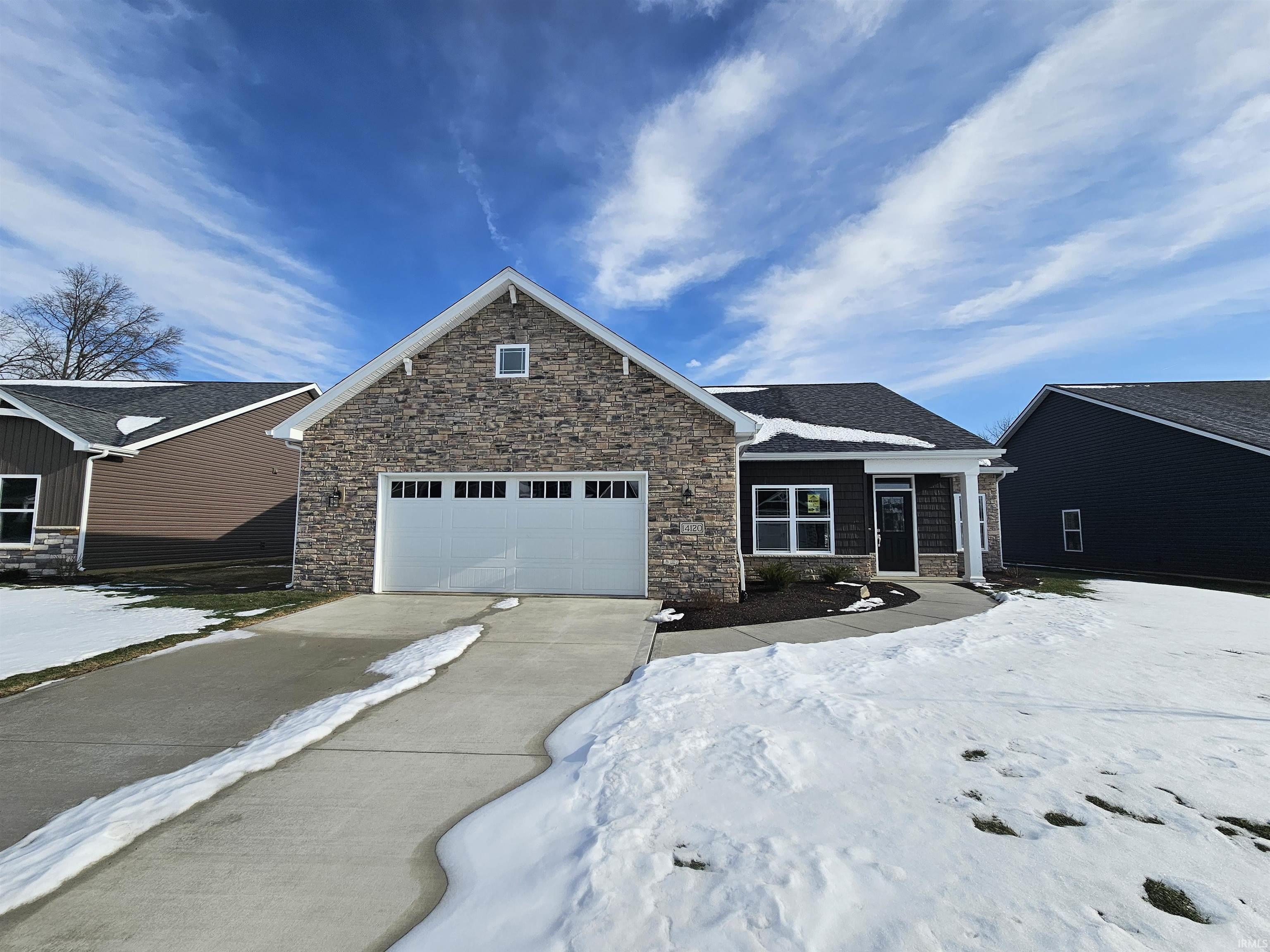 View of front of house featuring stone siding and driveway