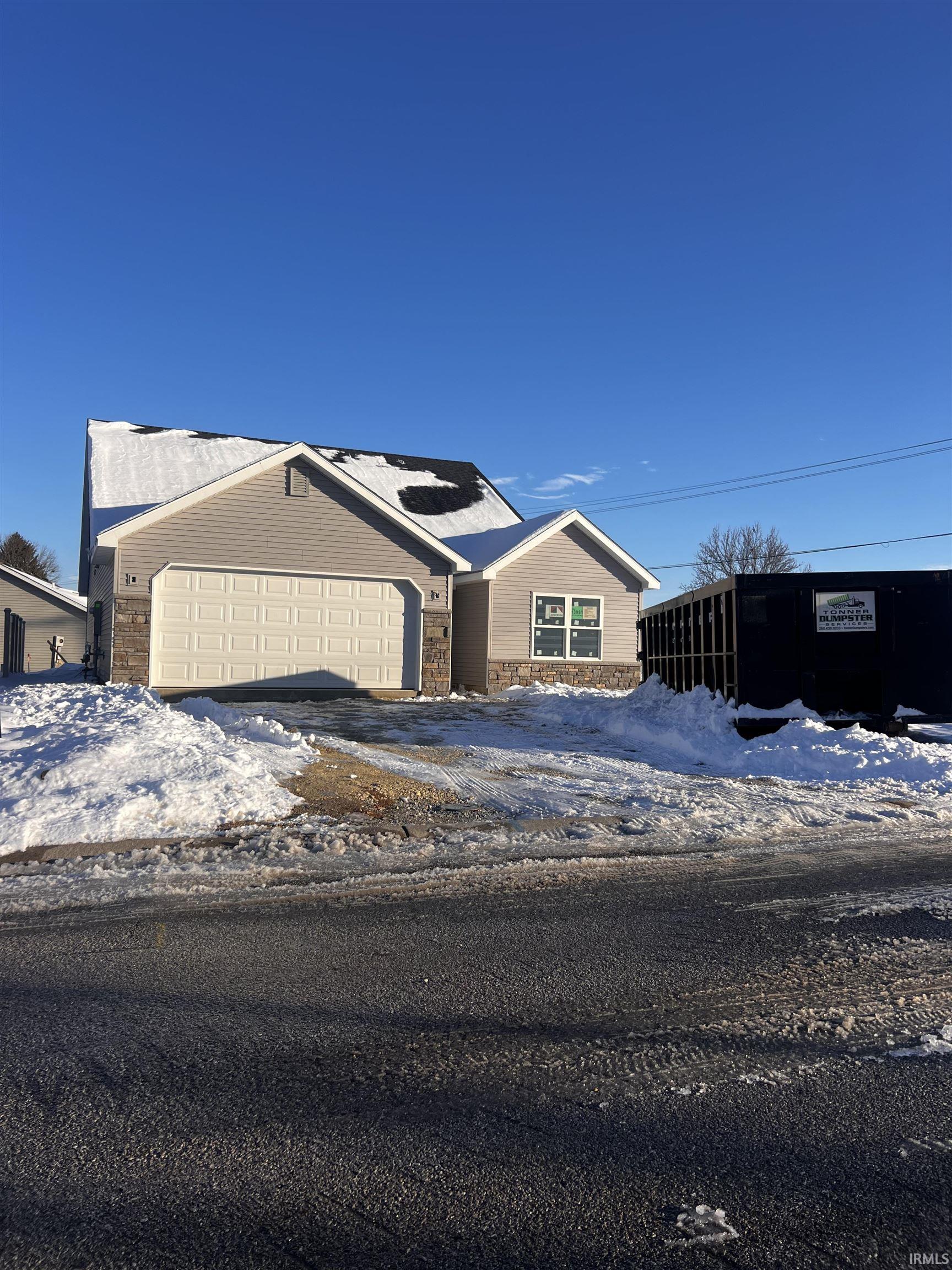 Ranch-style home with stone siding, driveway, and an attached garage