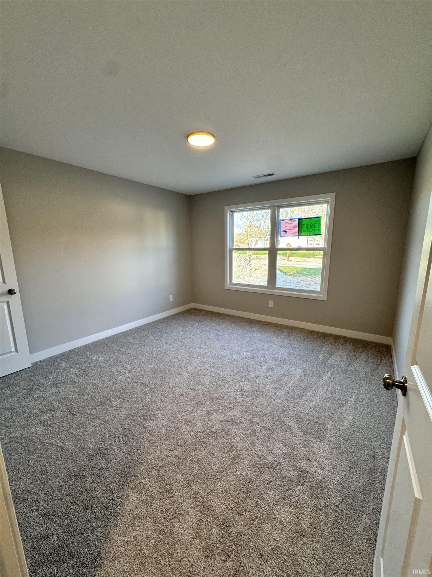 Carpeted empty room with baseboards