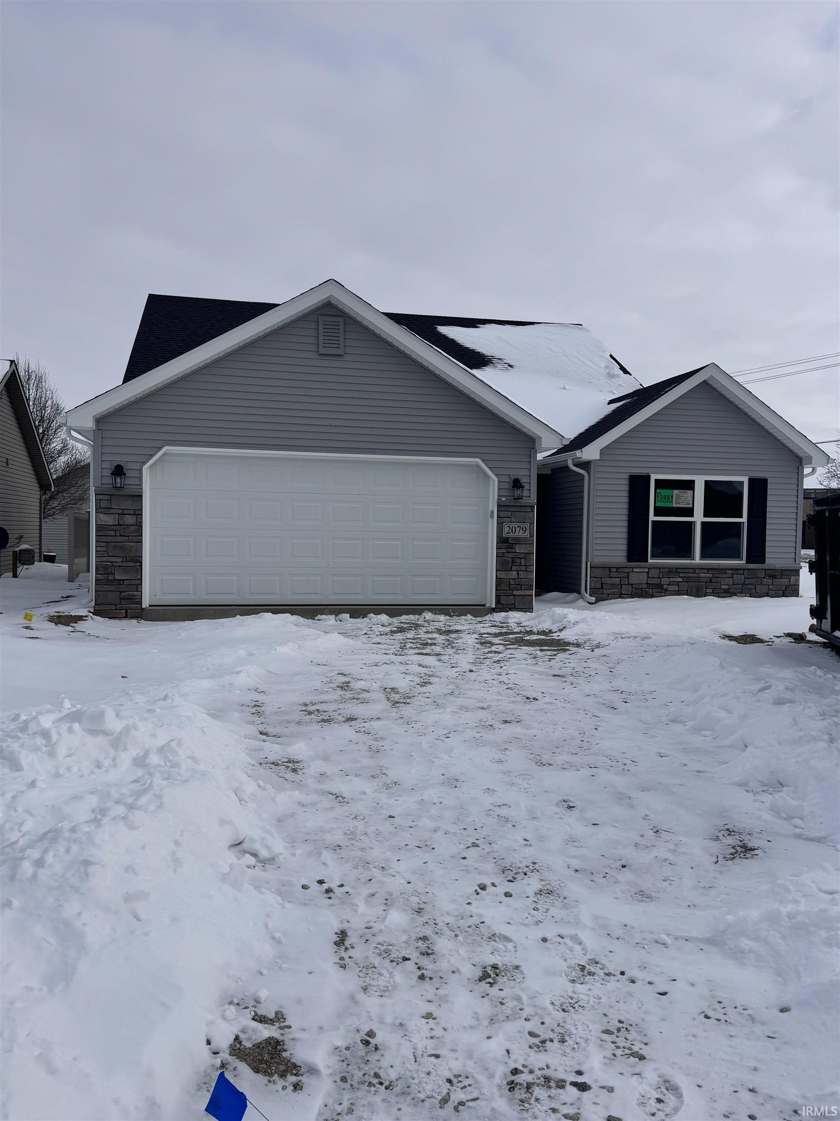 Single story home with stone siding and a garage