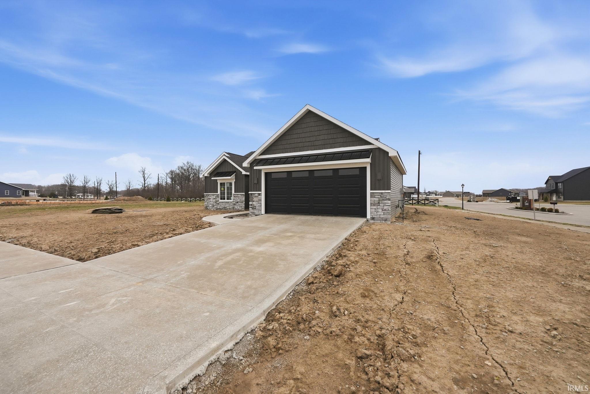 Craftsman inspired home with stone siding, concrete driveway, a garage, a residential view, and a standing seam roof