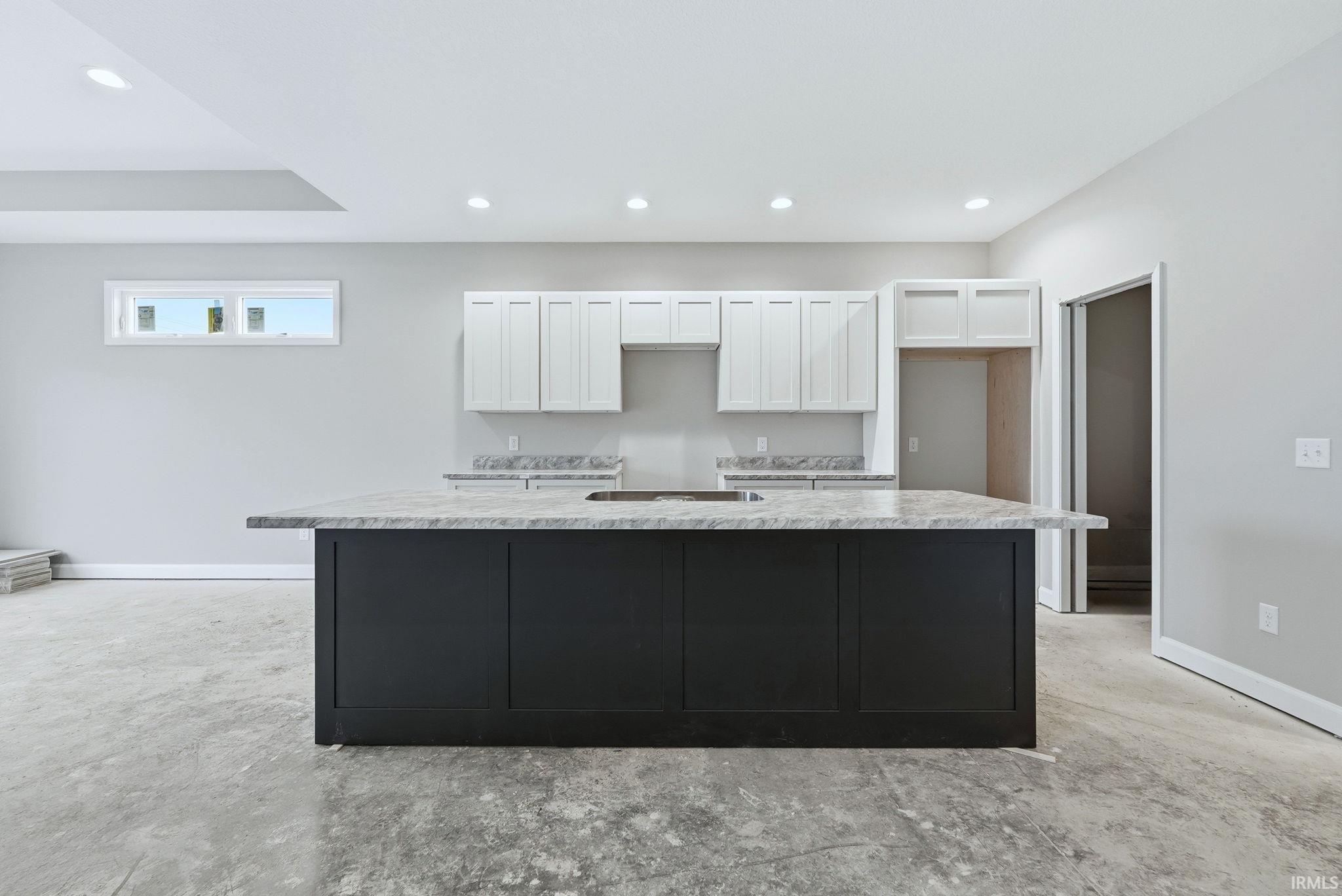 Kitchen featuring a center island, two tone cabinets, and recessed lighting