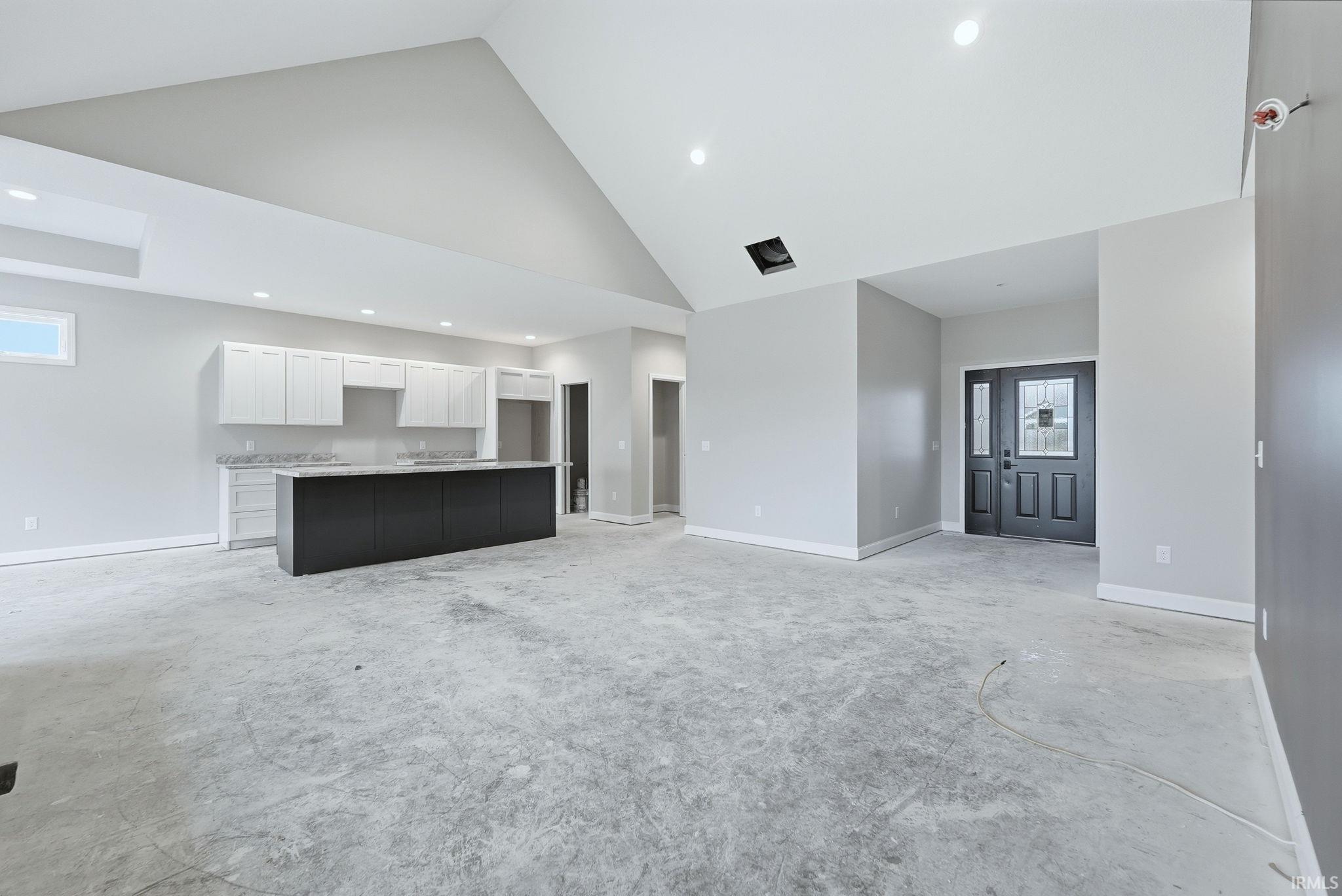 Unfurnished living room featuring lofted ceiling and recessed lighting