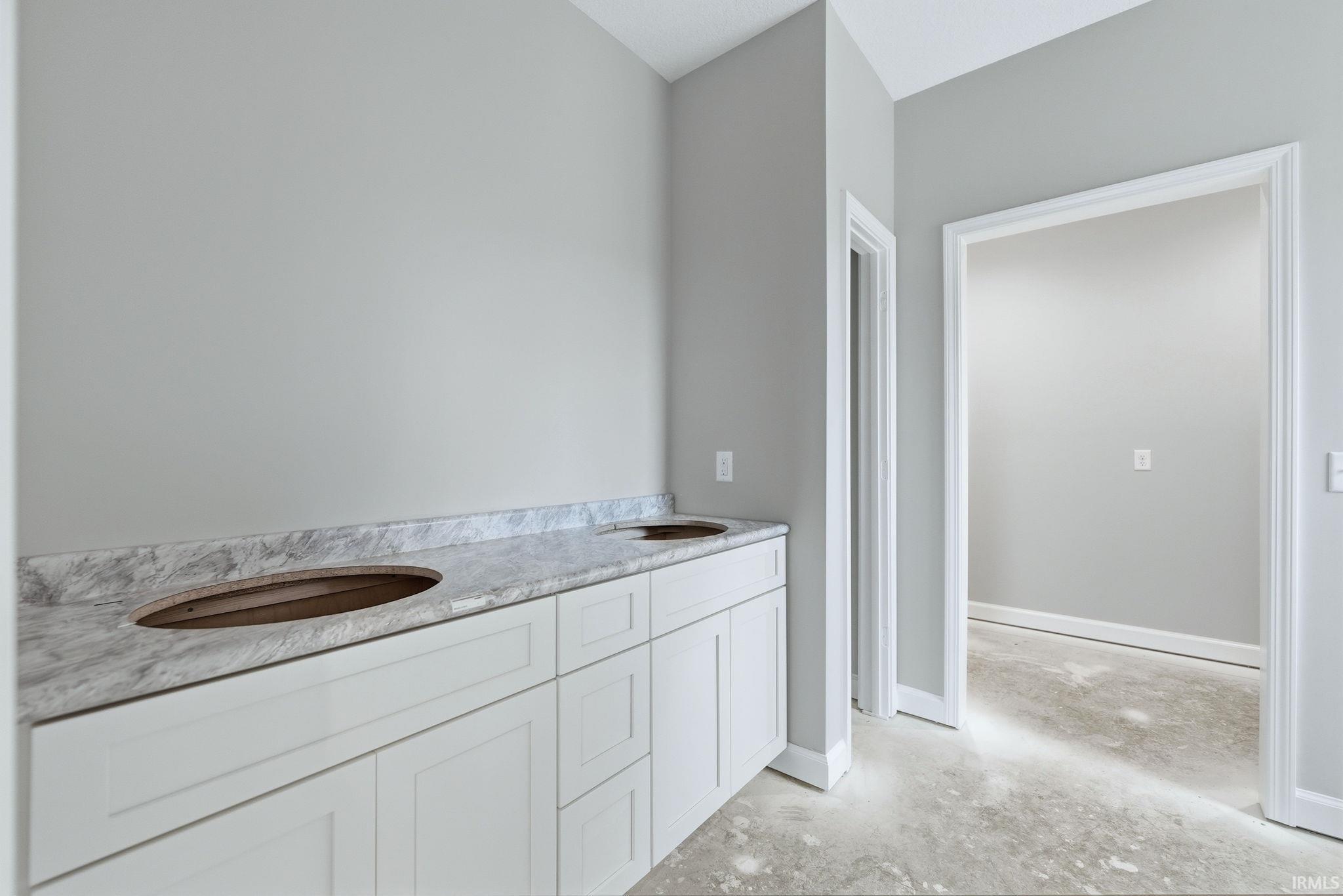 Bathroom with double vanity and baseboards