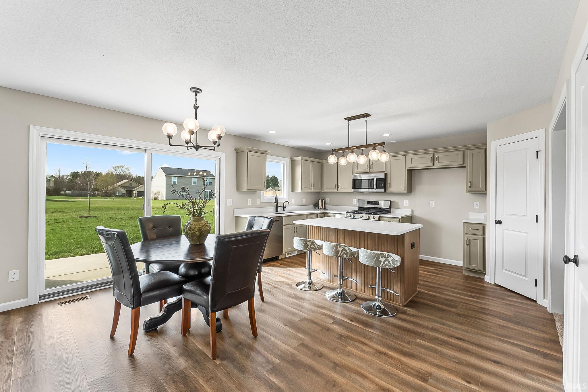 Dining area featuring hanging lights and dark wood-type flooring