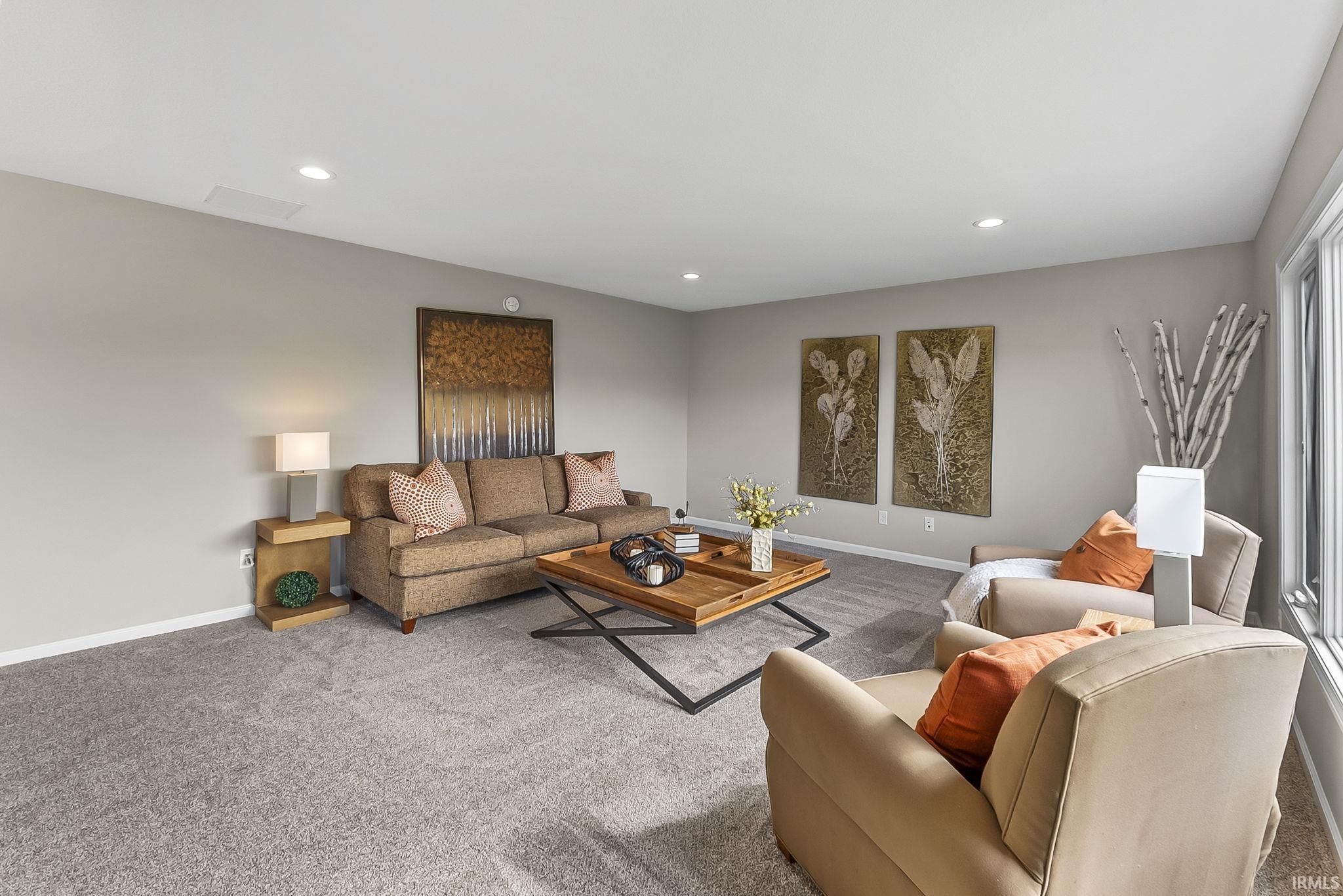 Carpeted living area with recessed lighting