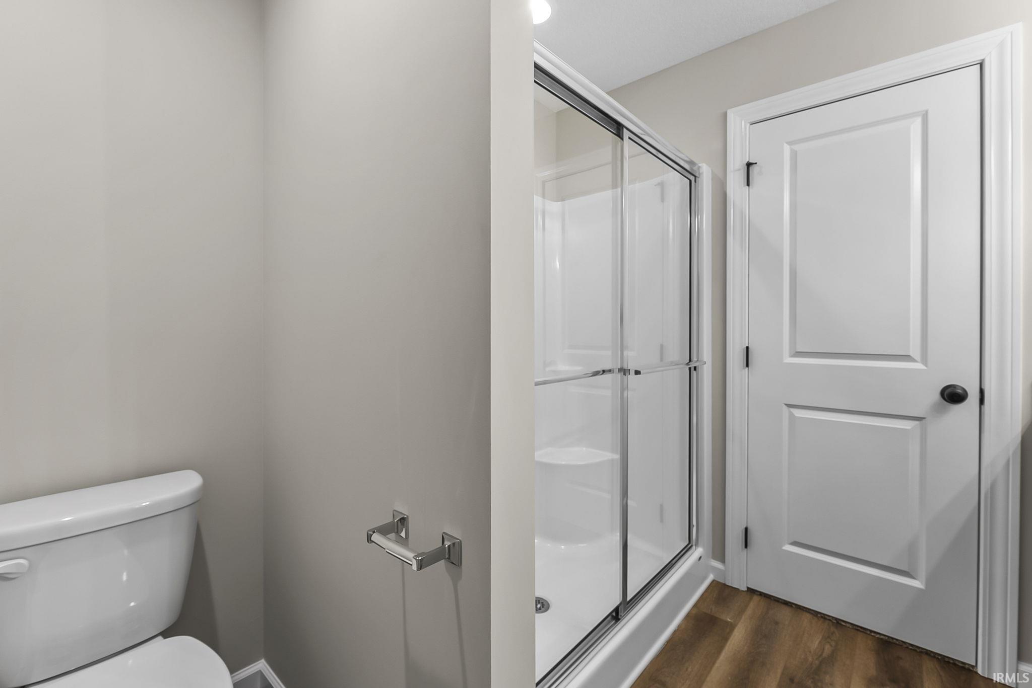 Bathroom with a shower stall and dark wood finished floors