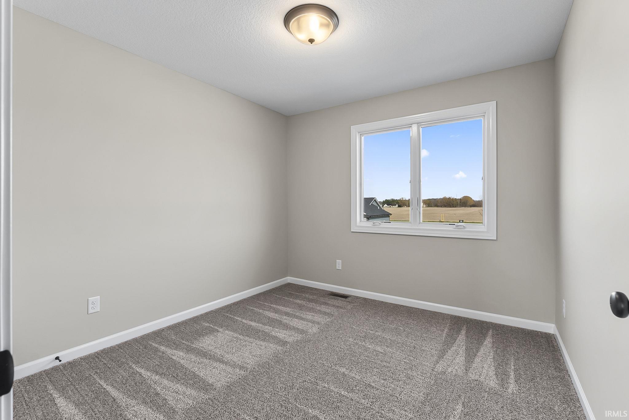 Spare room featuring baseboards and light colored carpet