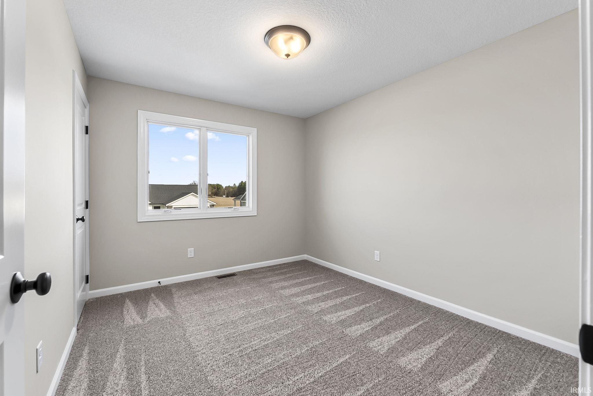 Unfurnished room featuring baseboards and light colored carpet