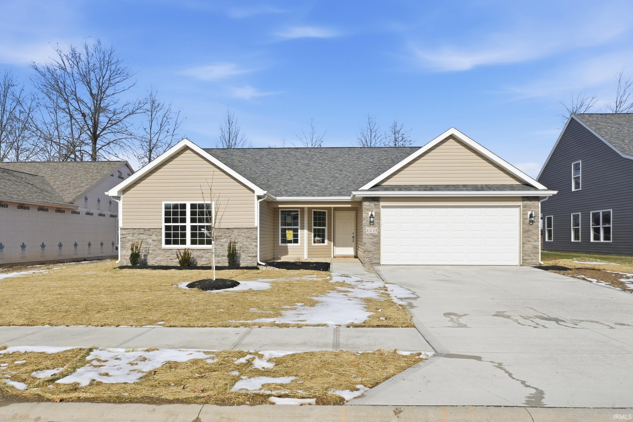 Ranch-style home featuring covered porch, concrete driveway, a garage, roof with shingles, and a front yard