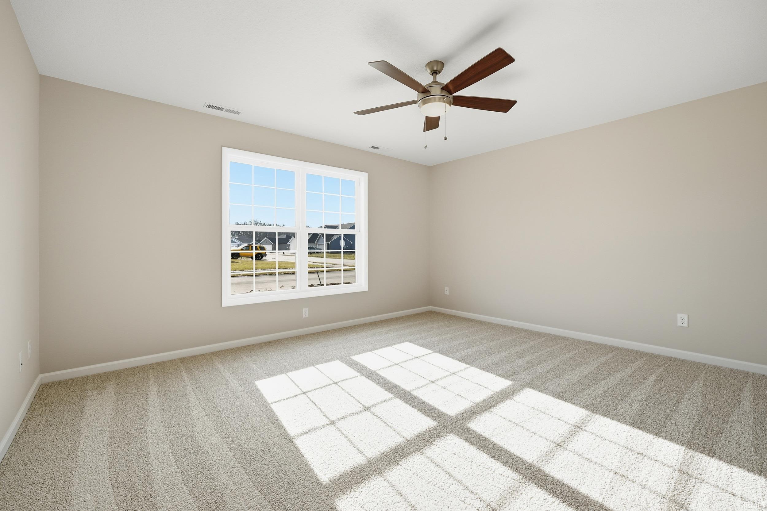 Spare room featuring light carpet and a ceiling fan