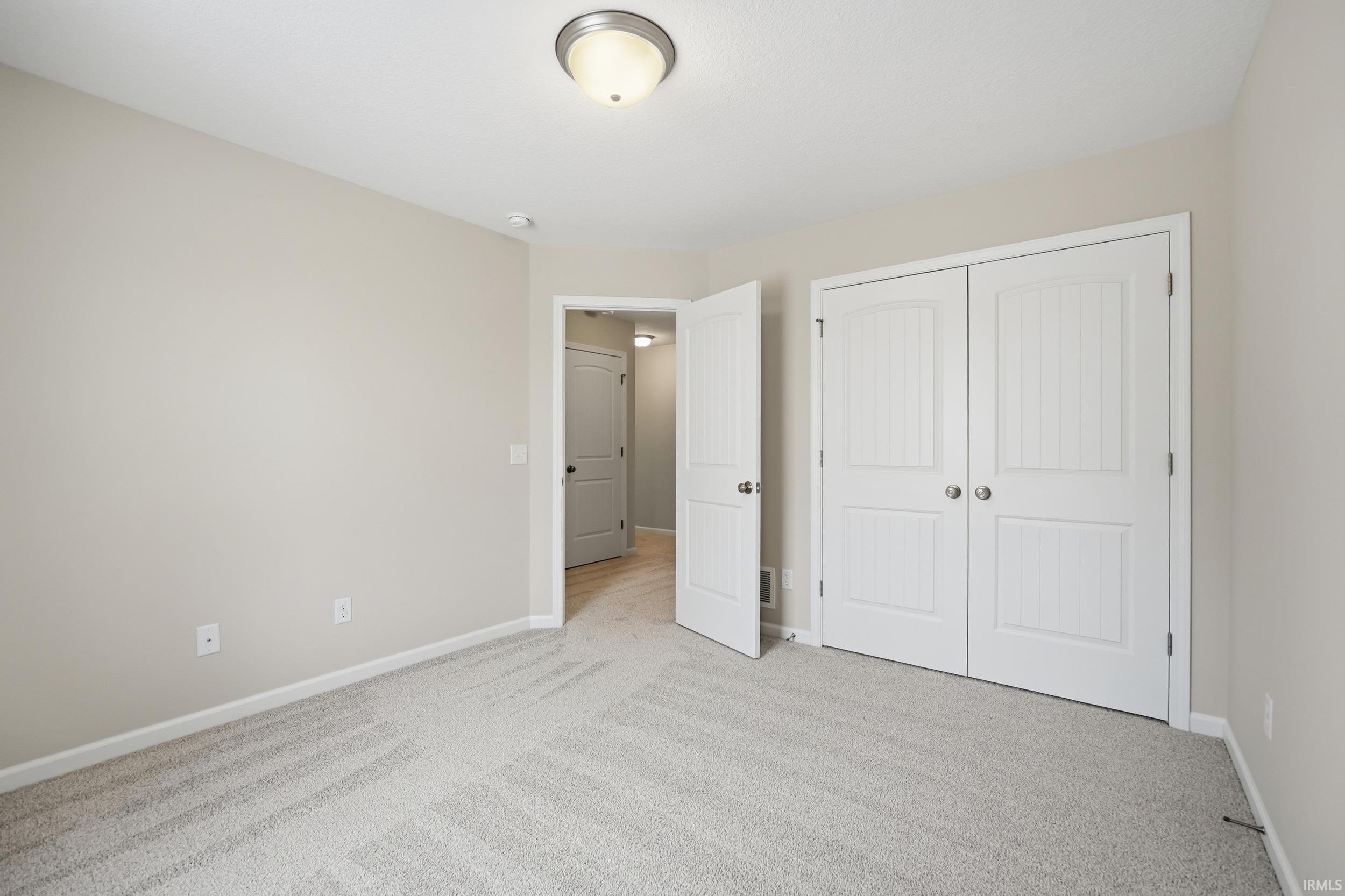 Unfurnished bedroom with carpet and a closet