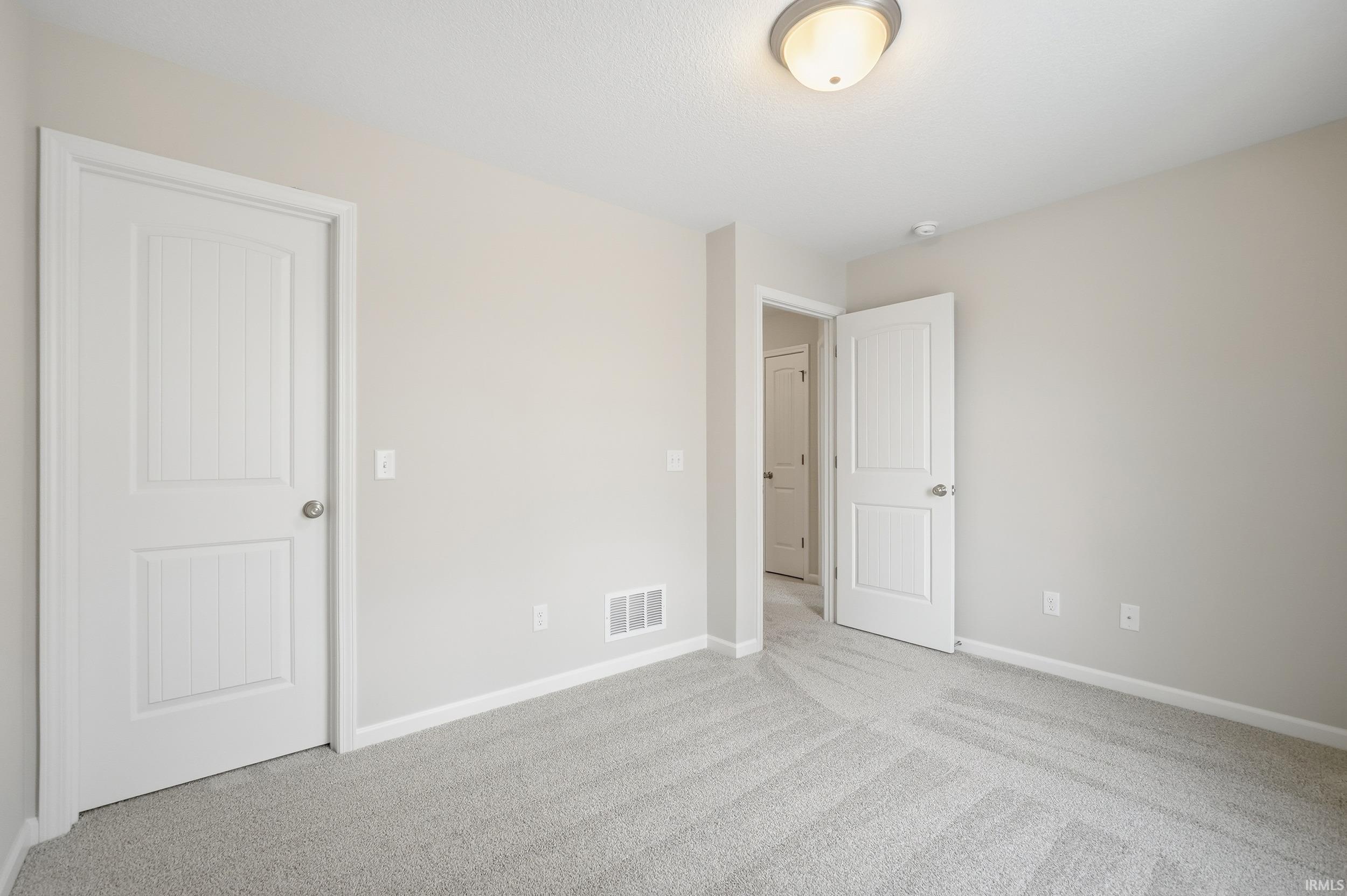 Unfurnished bedroom featuring carpet and baseboards