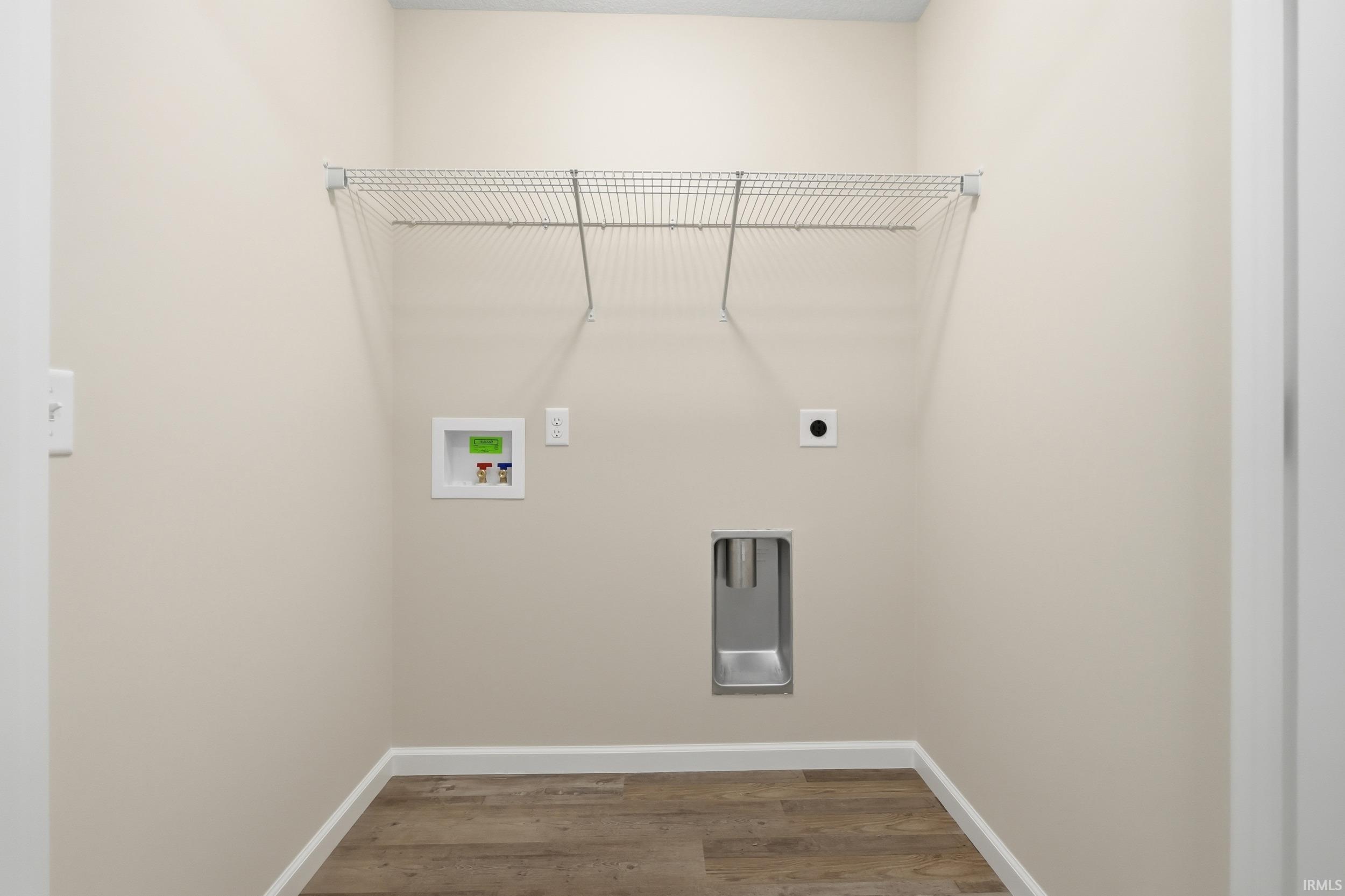 Laundry room with hookup for an electric dryer, wood finished floors, and hookup for a washing machine