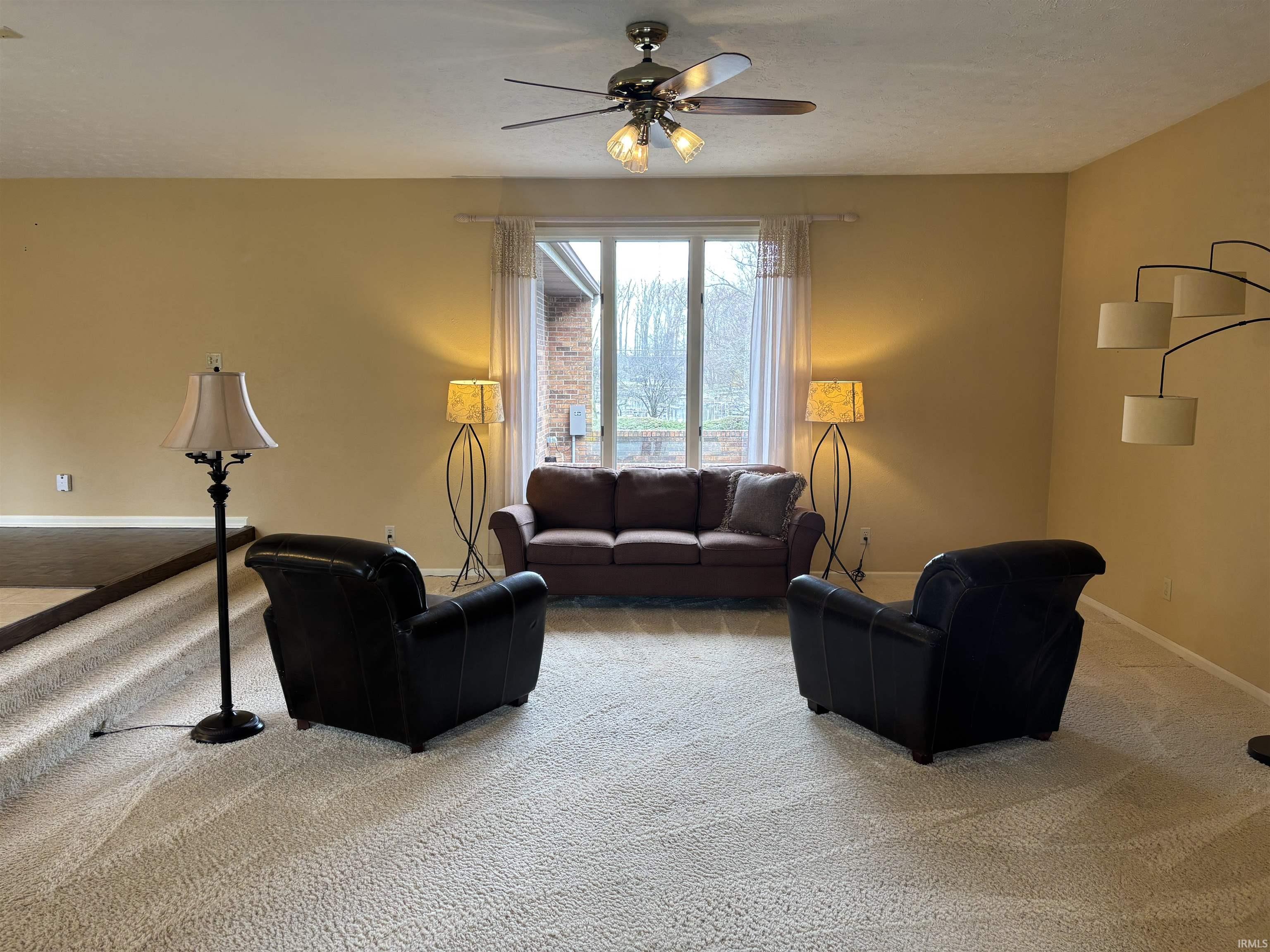 Living room featuring ceiling fan and carpet flooring