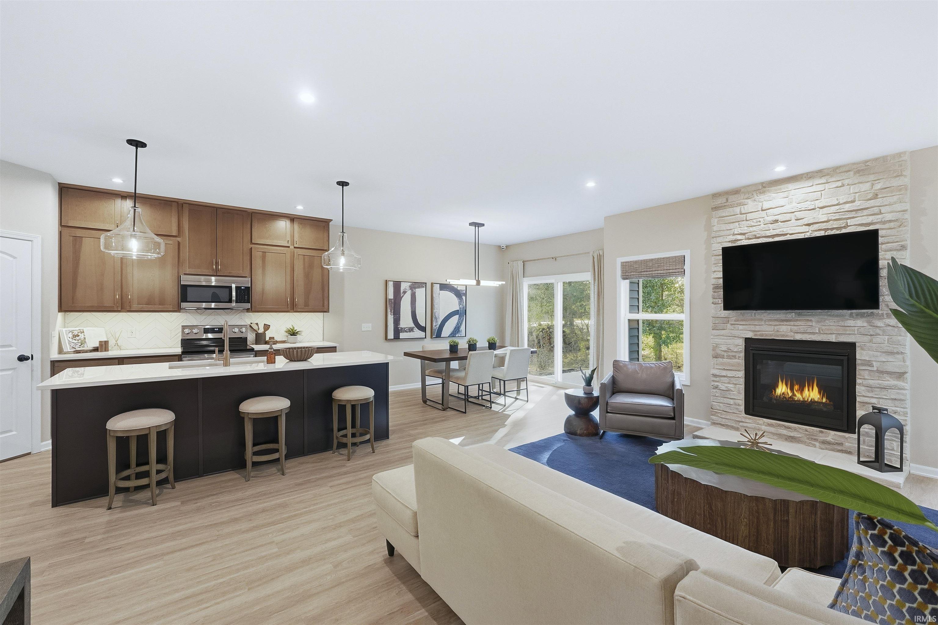 Great Room with light wood finished floors, a fireplace, and recessed lighting
