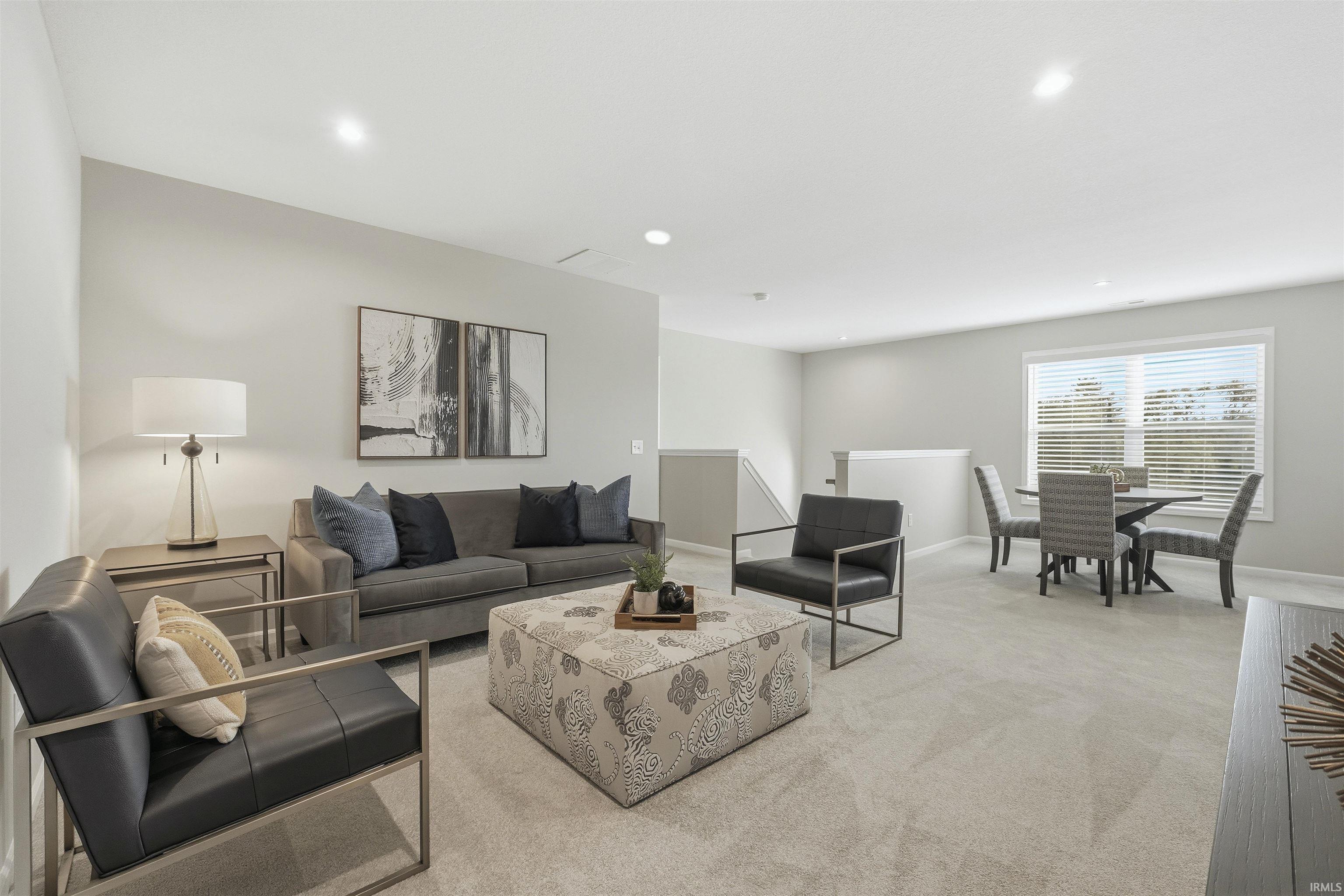 Carpeted living area featuring recessed lighting and baseboards