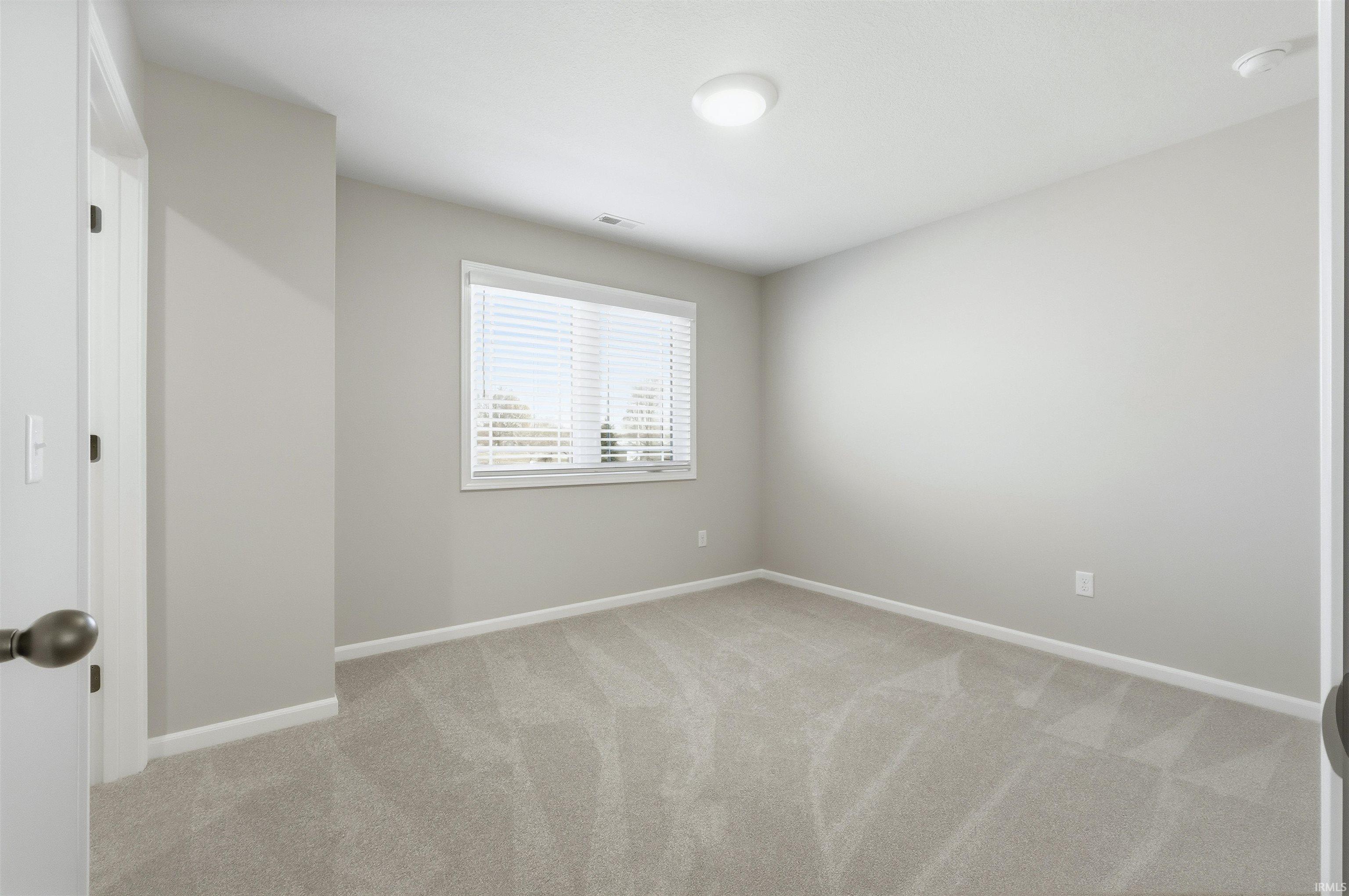 Unfurnished room with light colored carpet and baseboards