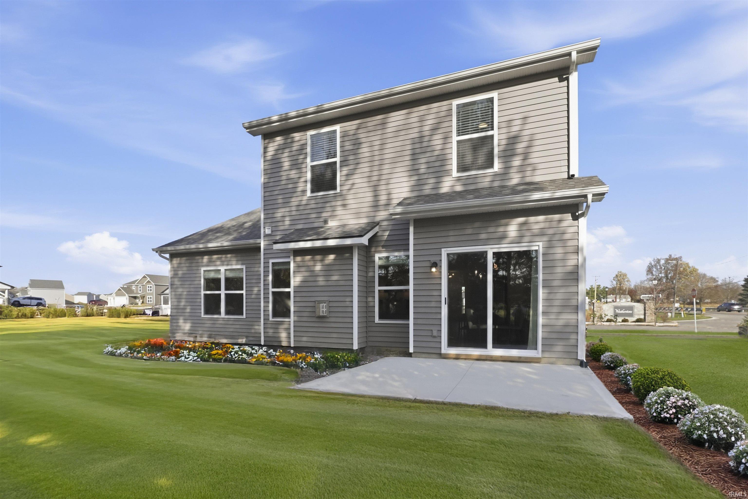 Rear view of property featuring a lawn and a patio