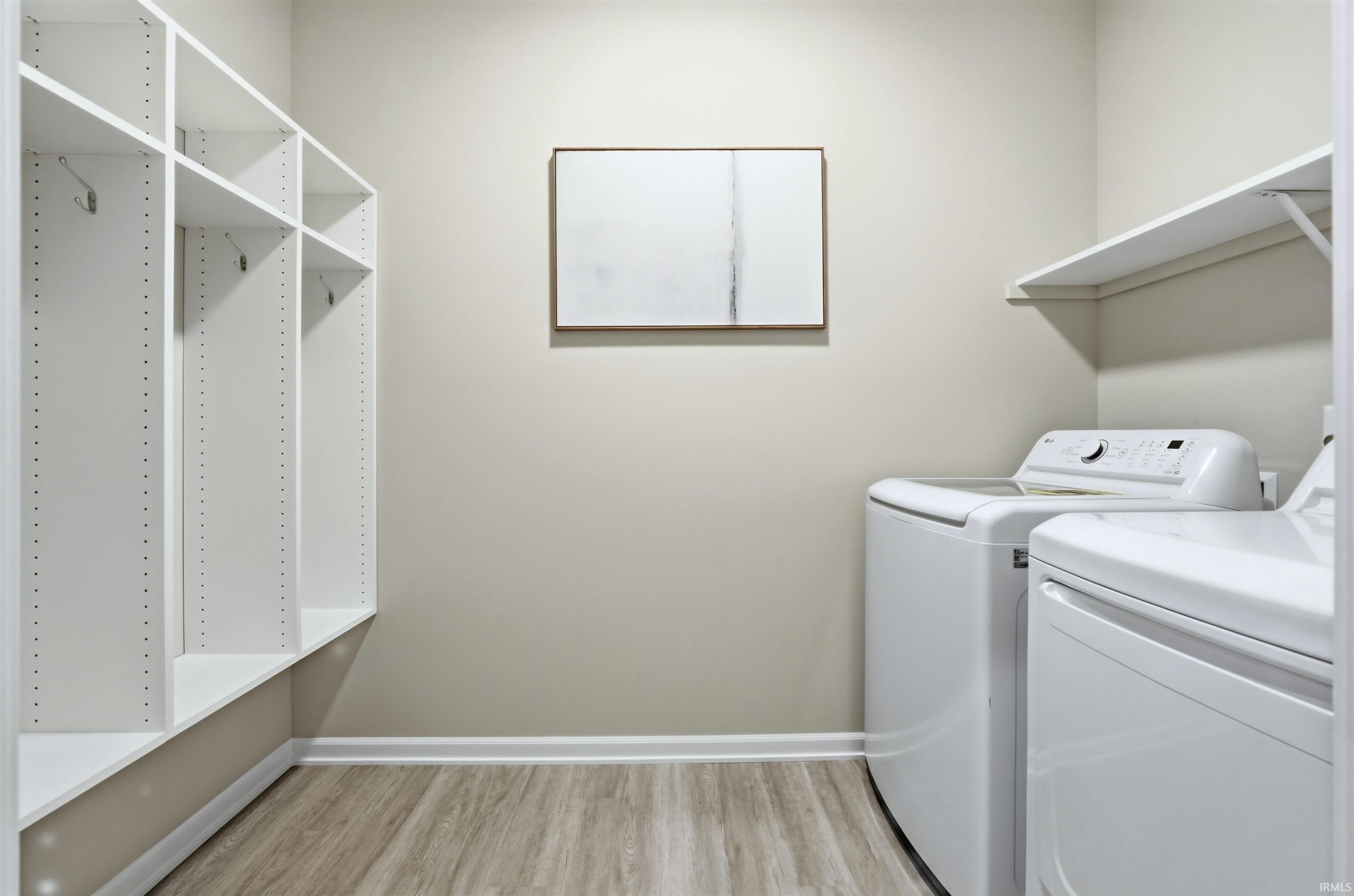 Laundry area featuring light wood-type flooring and washing machine and dryer