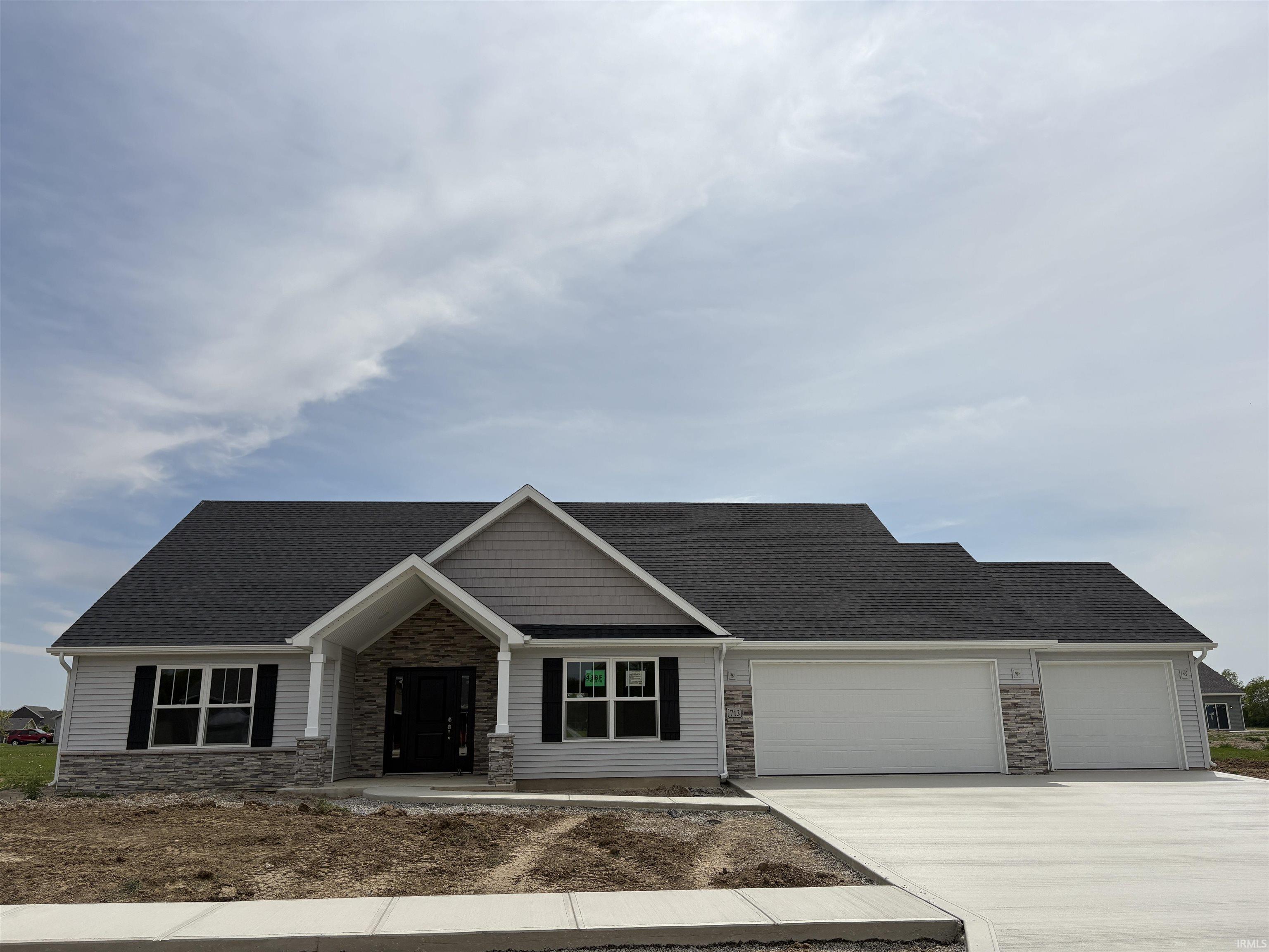 Single-story residence featuring light gray siding with stone accents