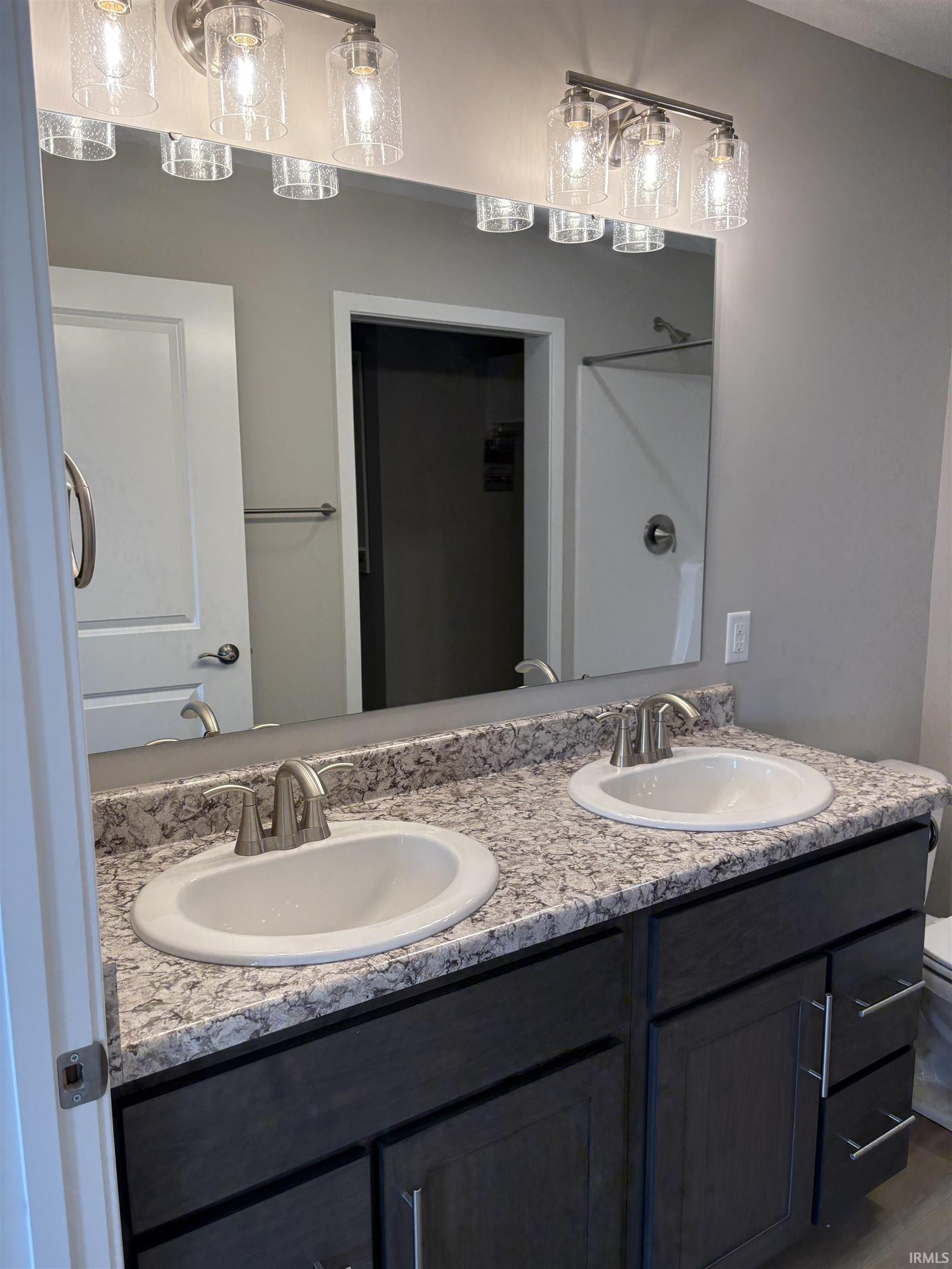 Double vanity featuring undermount sinks, brushed nickel faucets, and a speckled countertop