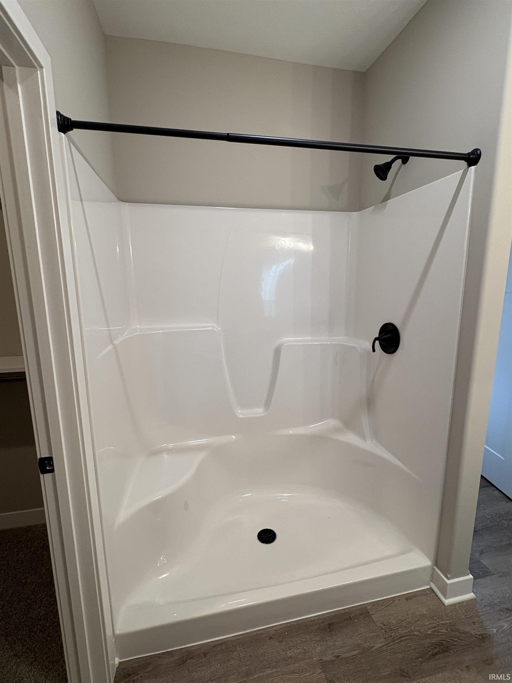Integrated shower unit featuring a black shower head and control