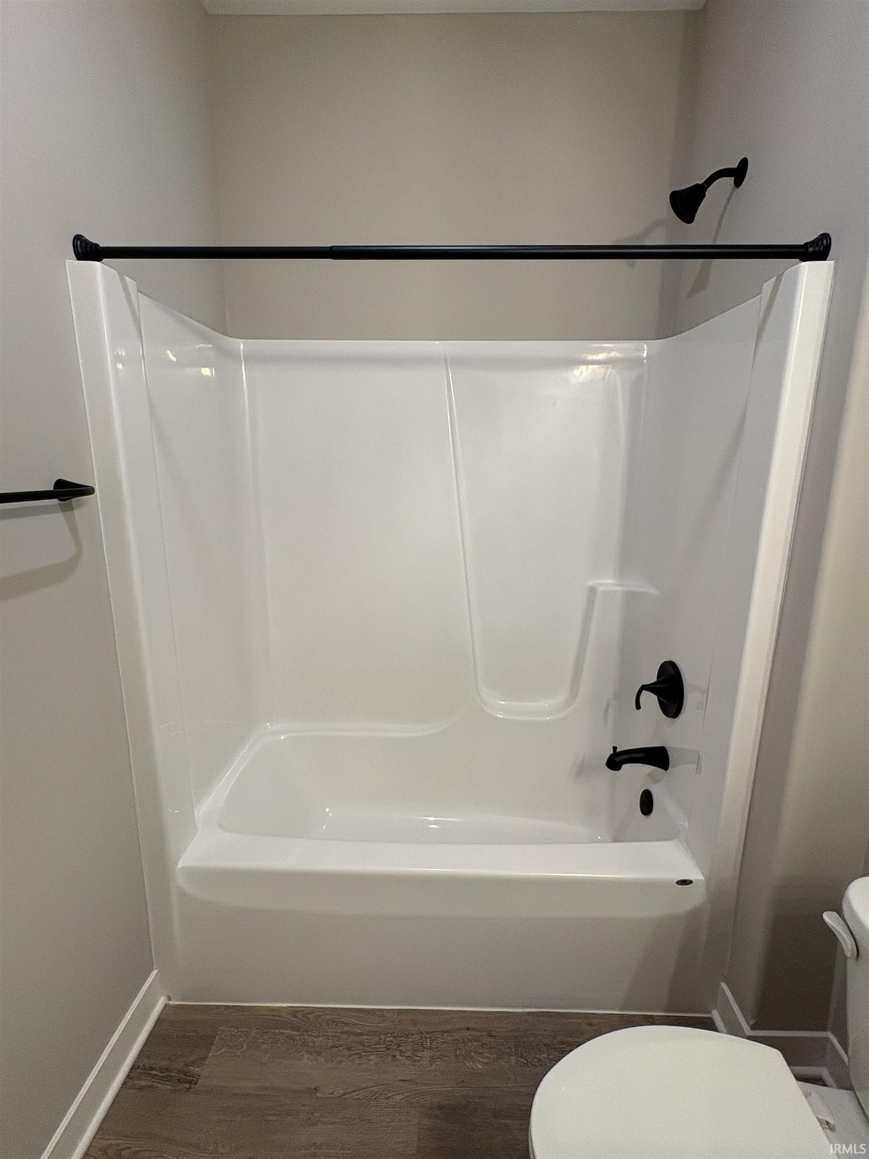 White acrylic tub and shower combination with matte black fixtures
