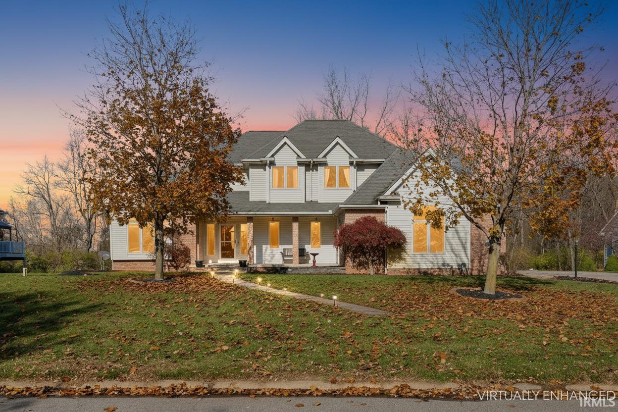 Traditional-style home featuring covered porch, a front yard, and a shingled roof