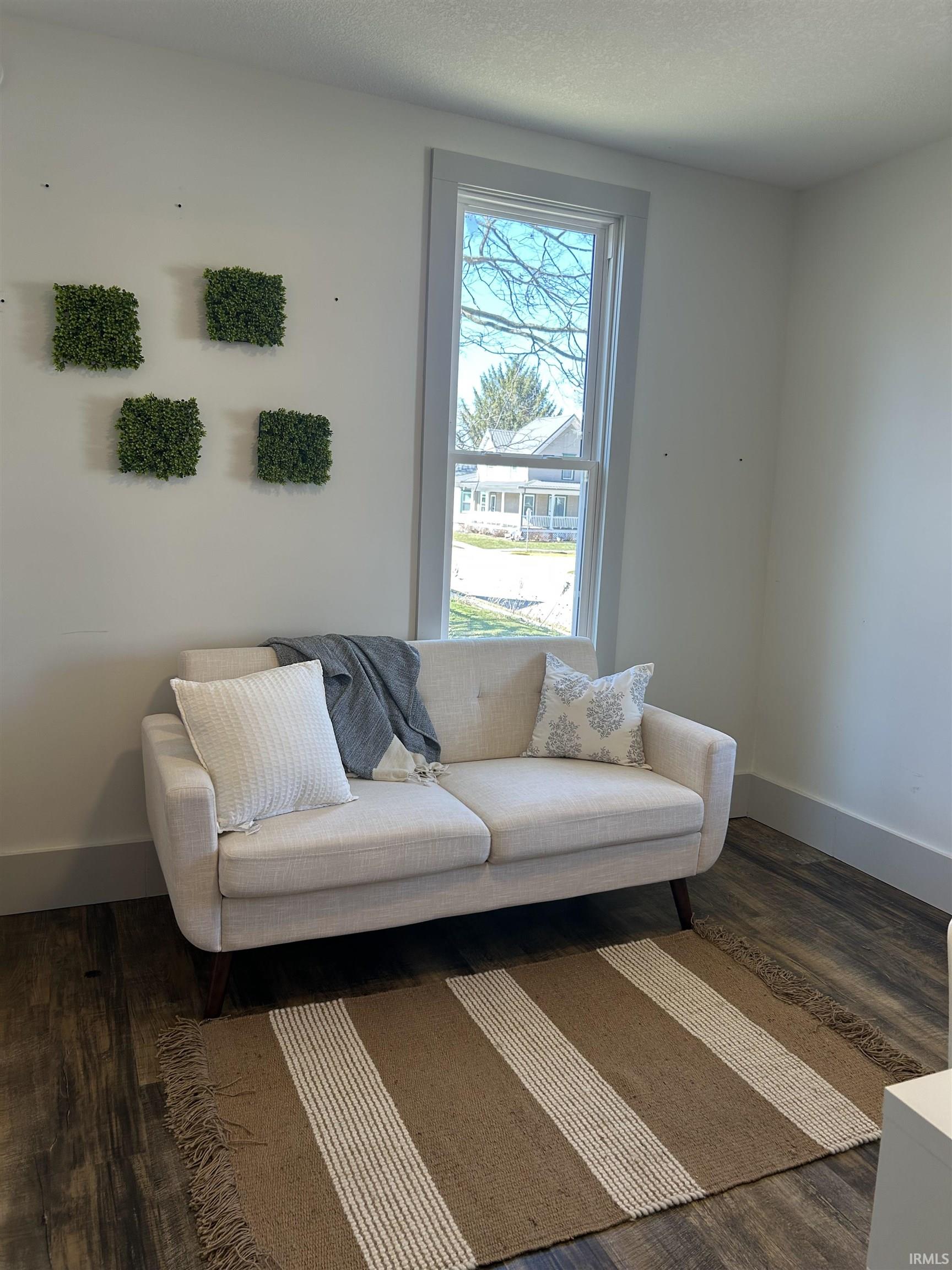 Sitting room with dark wood-style floors and a textured ceiling