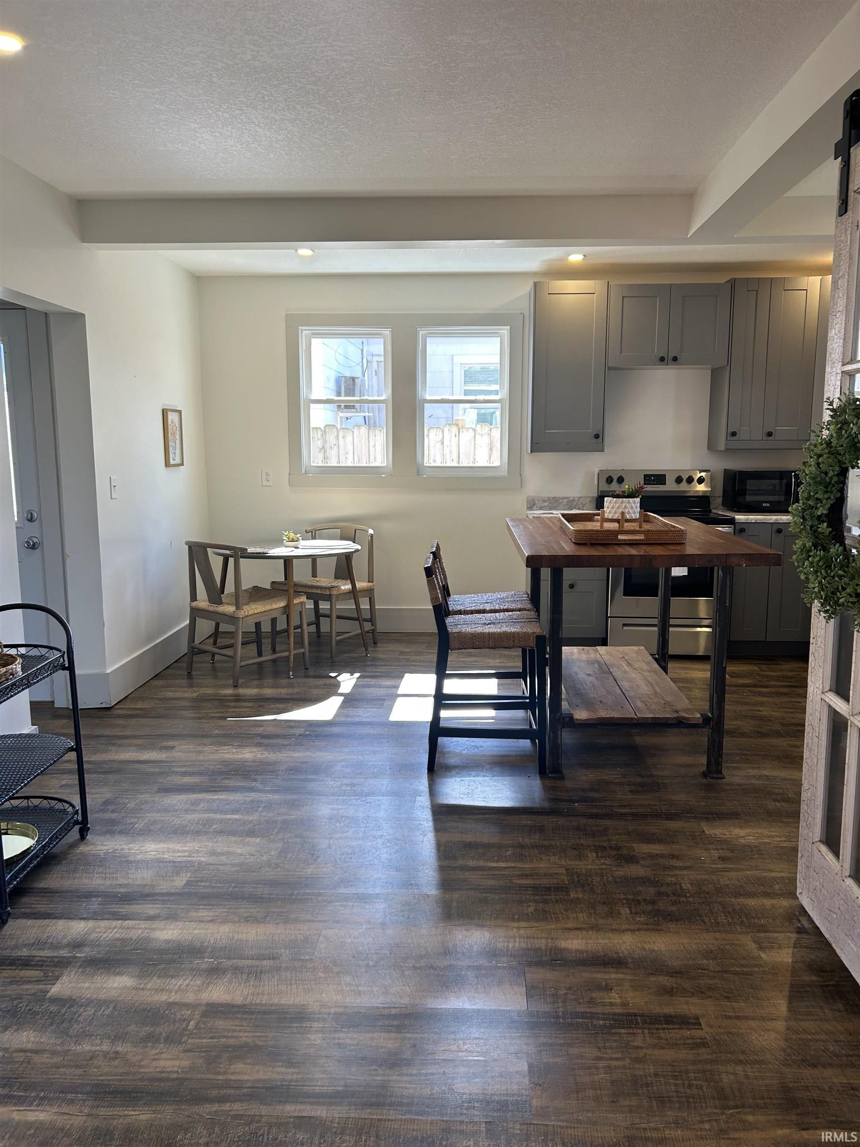 Dining area featuring a textured ceiling, dark wood-type flooring, recessed lighting, and a barn door