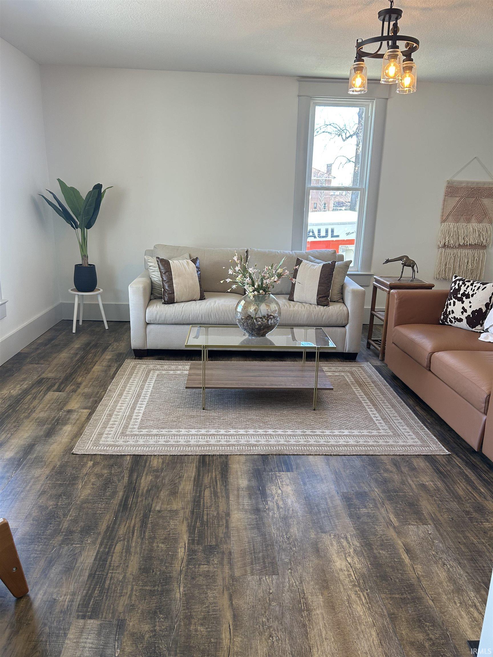 Living area featuring dark wood-style floors and a textured ceiling