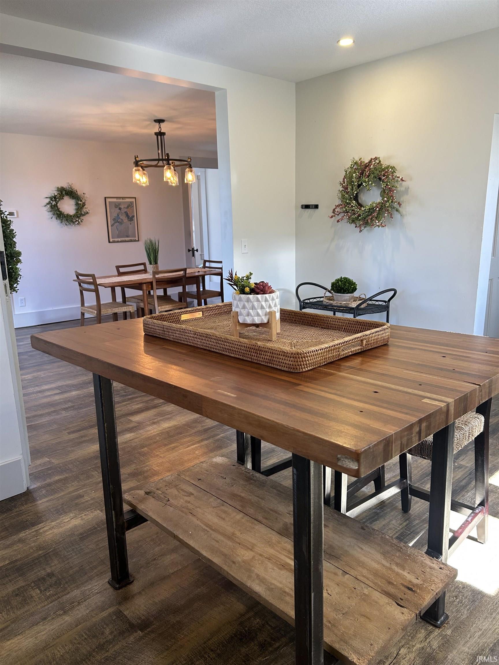 Dining space featuring dark wood finished floors and a chandelier