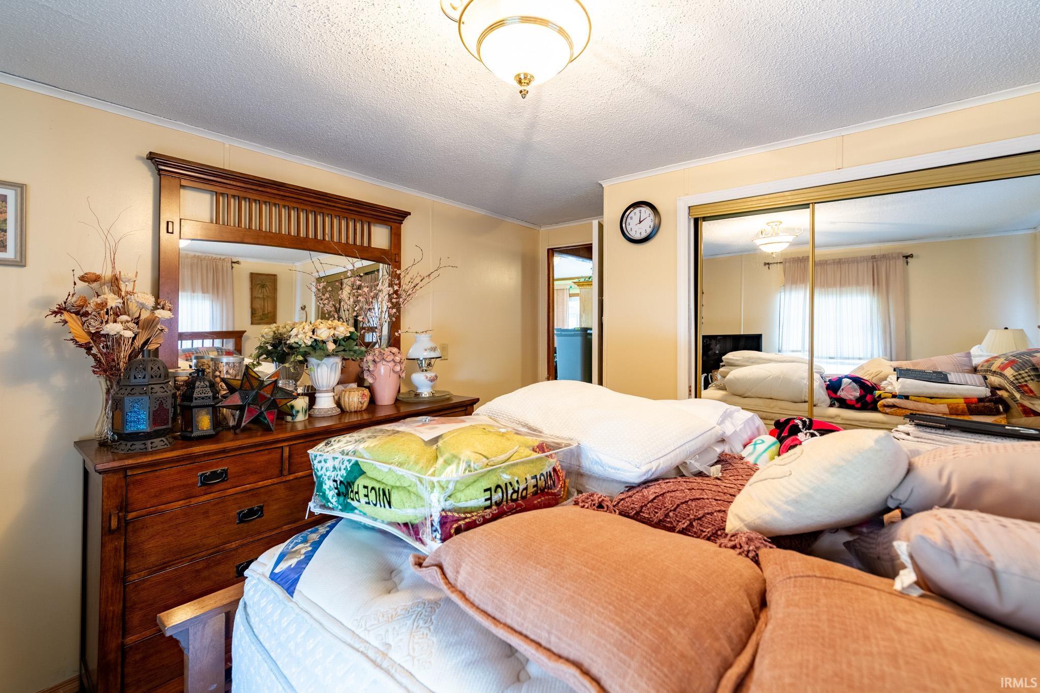 Bedroom with crown molding, a closet, and a textured ceiling