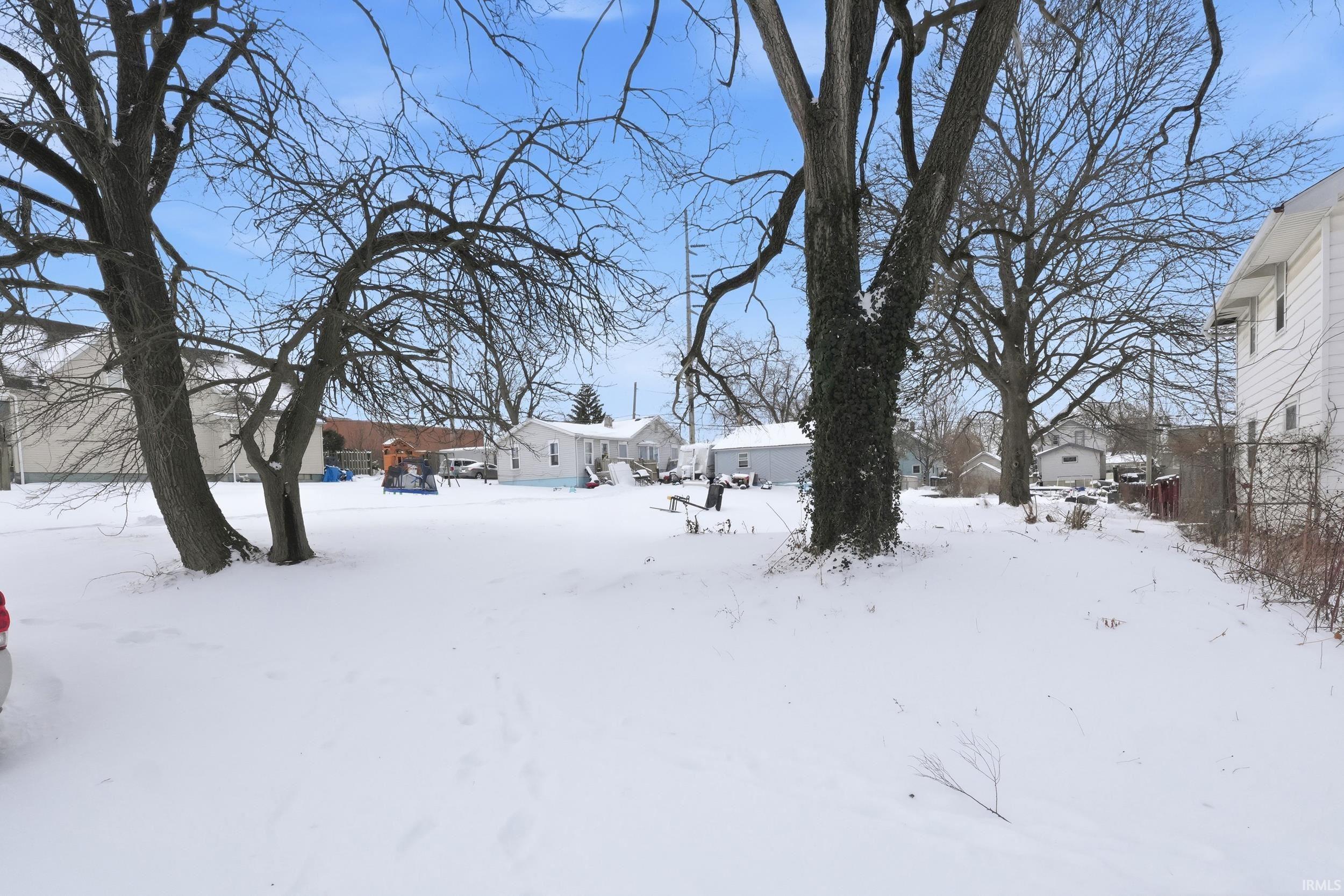 Yard layered in snow featuring a residential view
