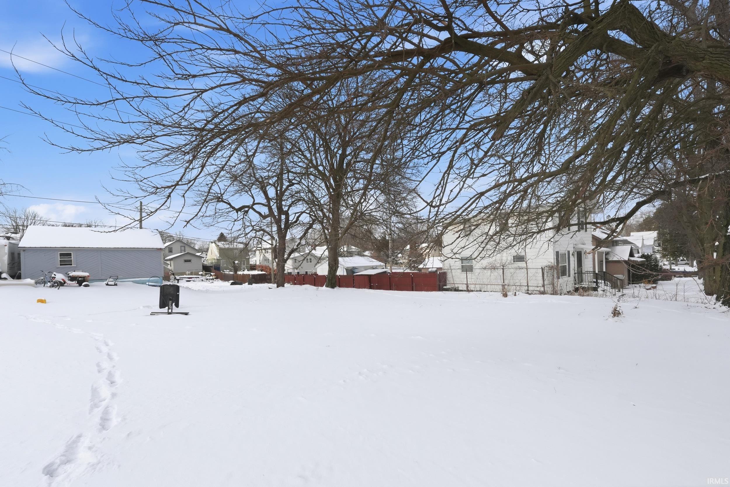 Yard covered in snow featuring a residential view