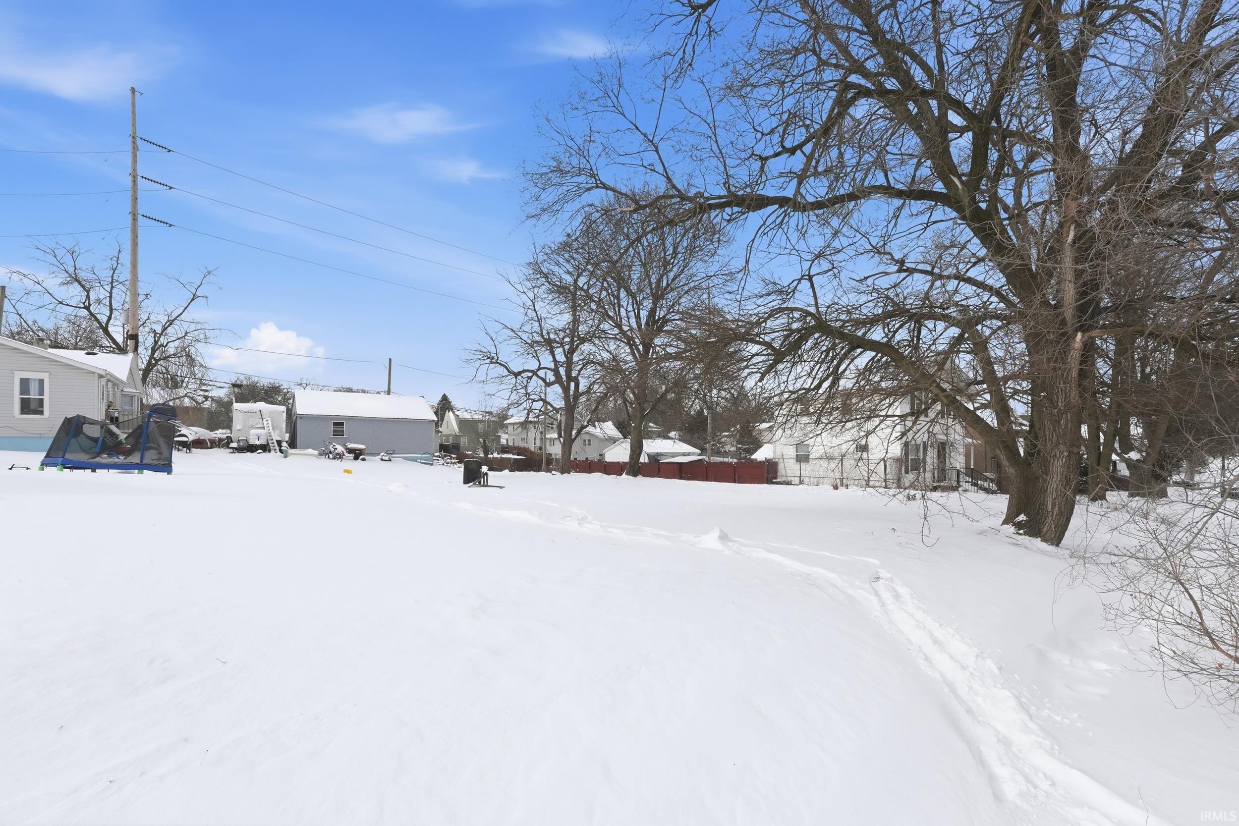 Yard layered in snow with a residential view