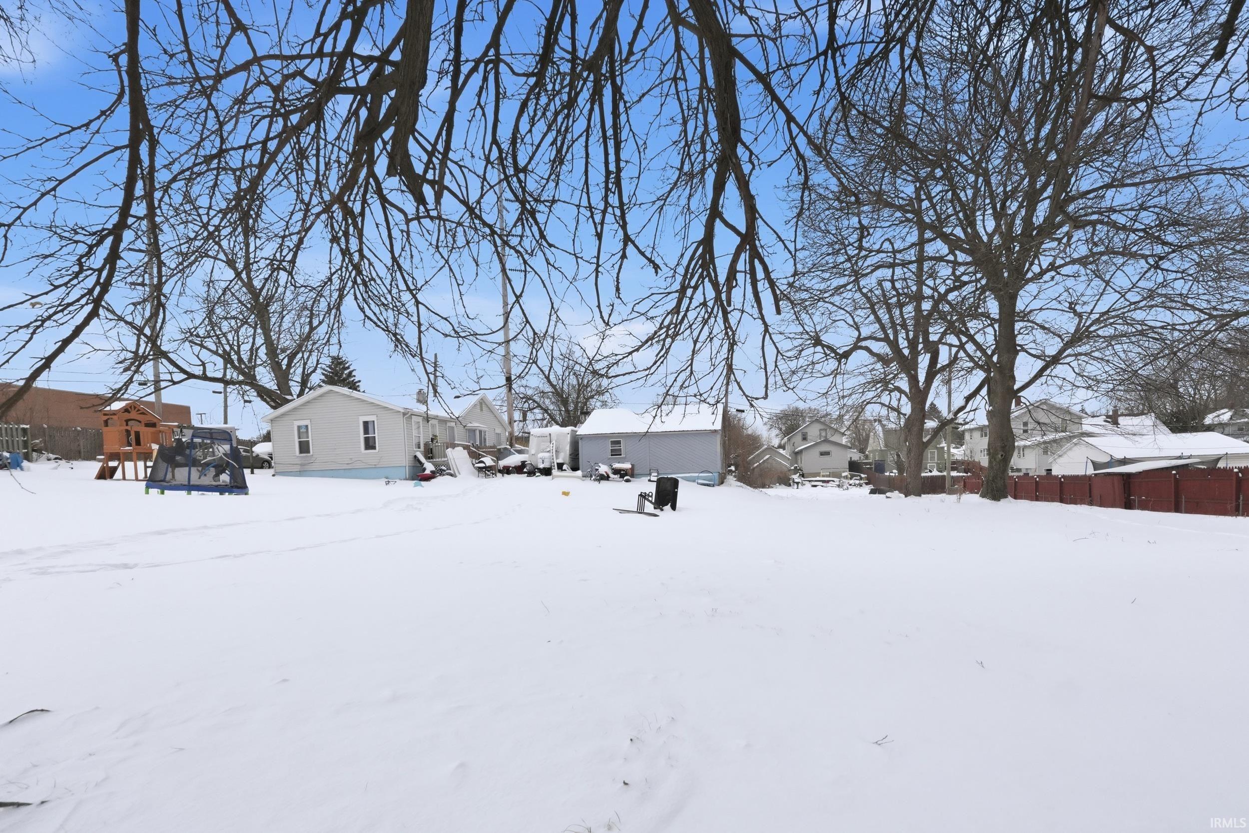 Snowy yard featuring a residential view