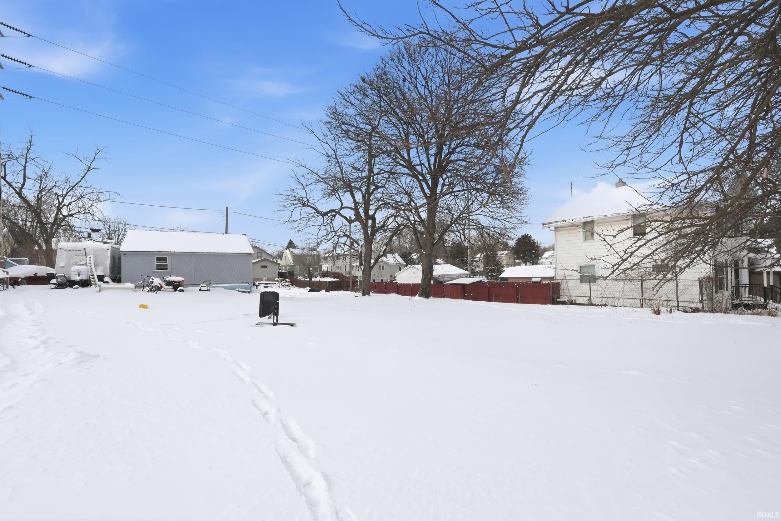 Yard covered in snow featuring a residential view