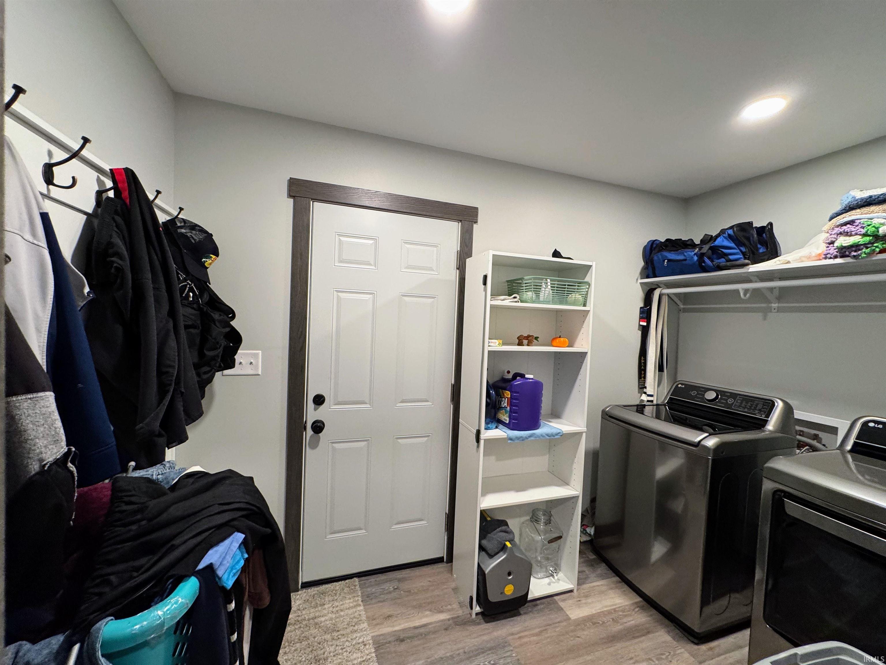 Laundry room featuring light wood finished floors and washing machine and clothes dryer
