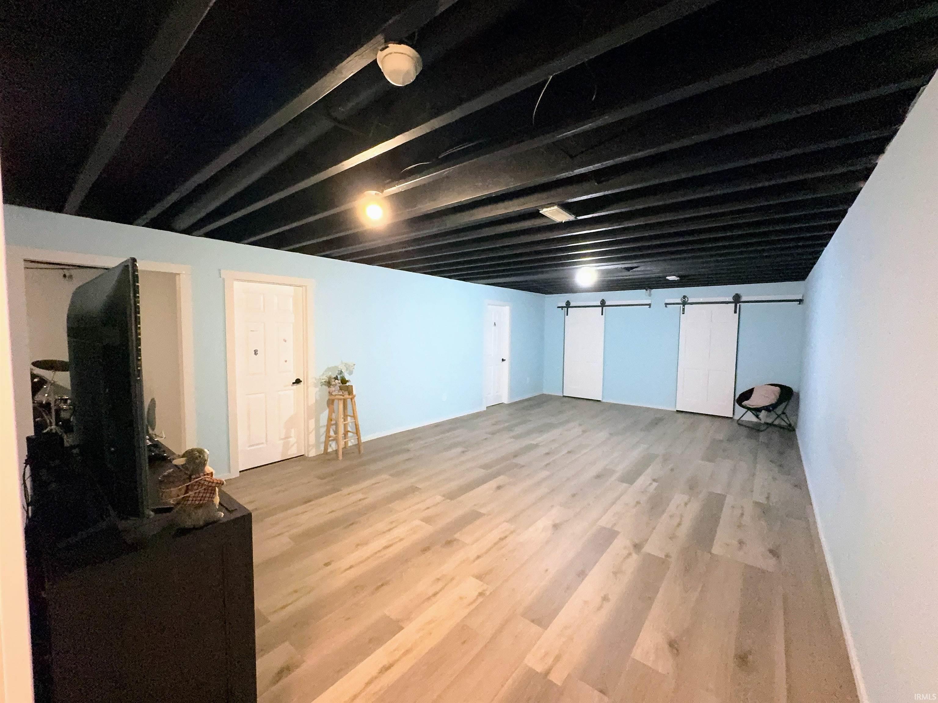 Below grade area featuring a barn door and light wood-type flooring