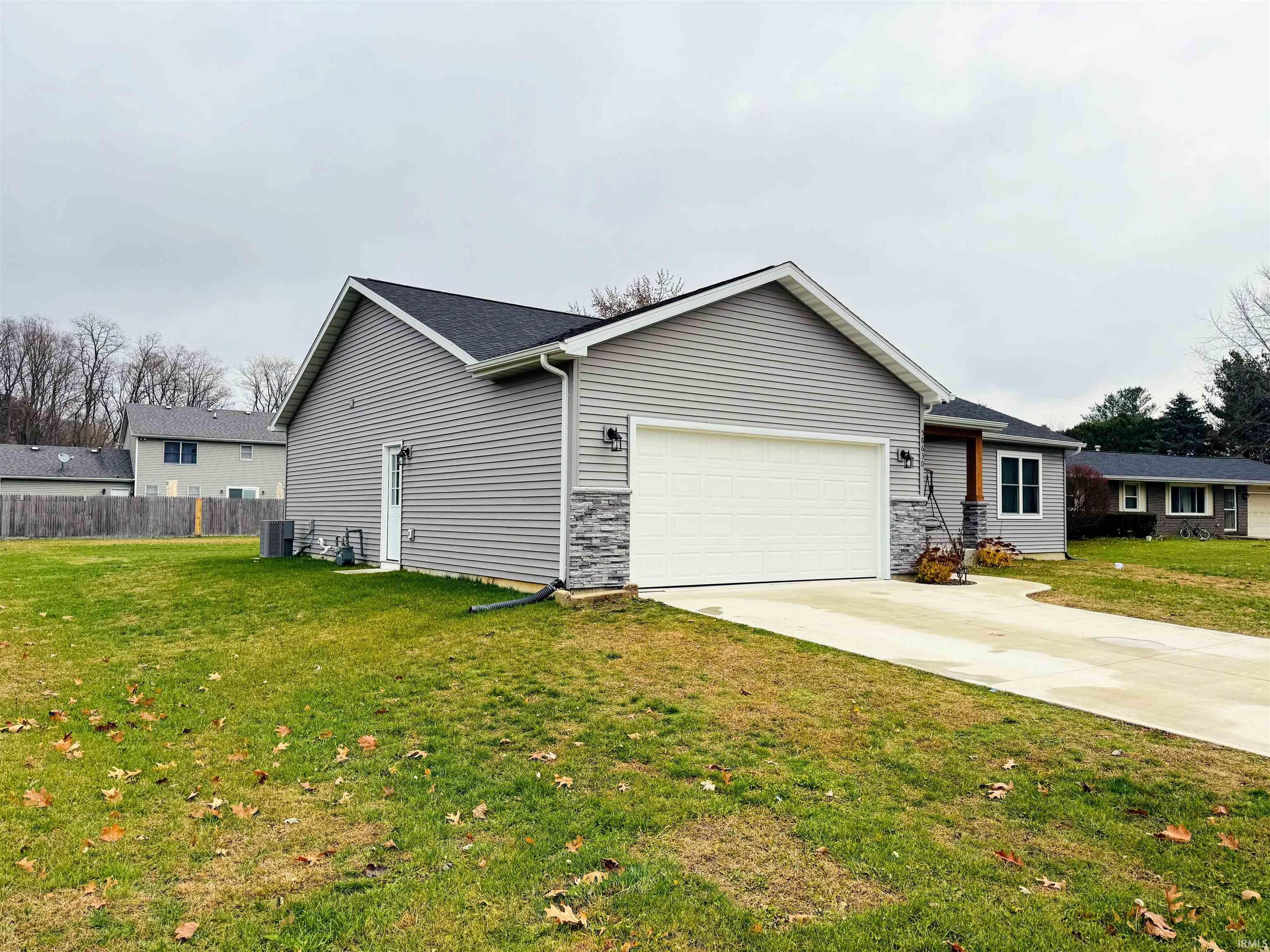 View of side of property featuring concrete driveway and a garage