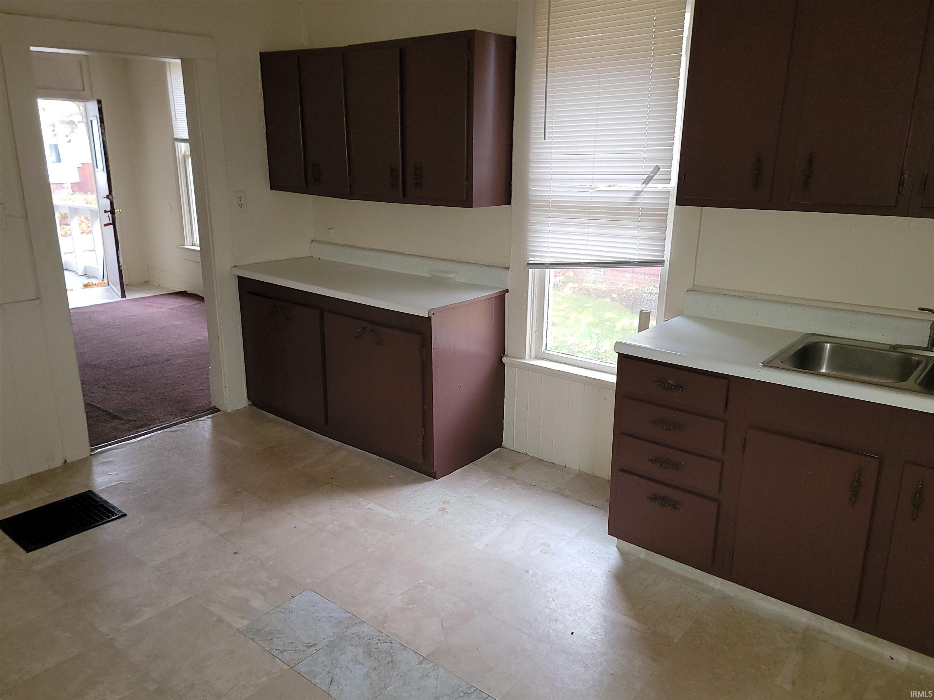 Kitchen featuring dark brown cabinetry and light countertops