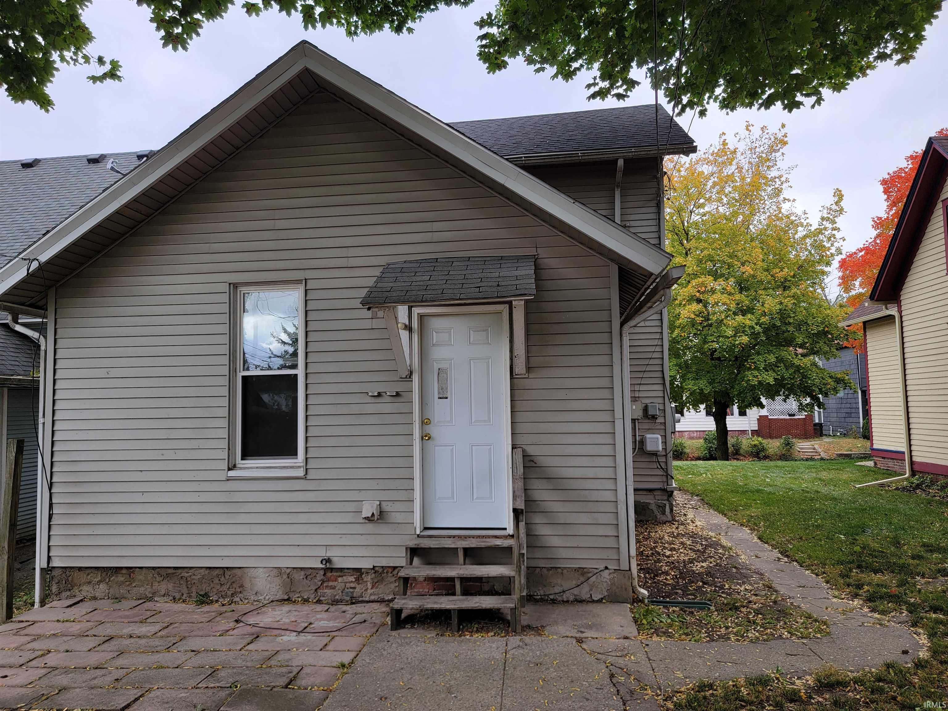 View of front of home with a shingled roof, entry steps, and a front yard