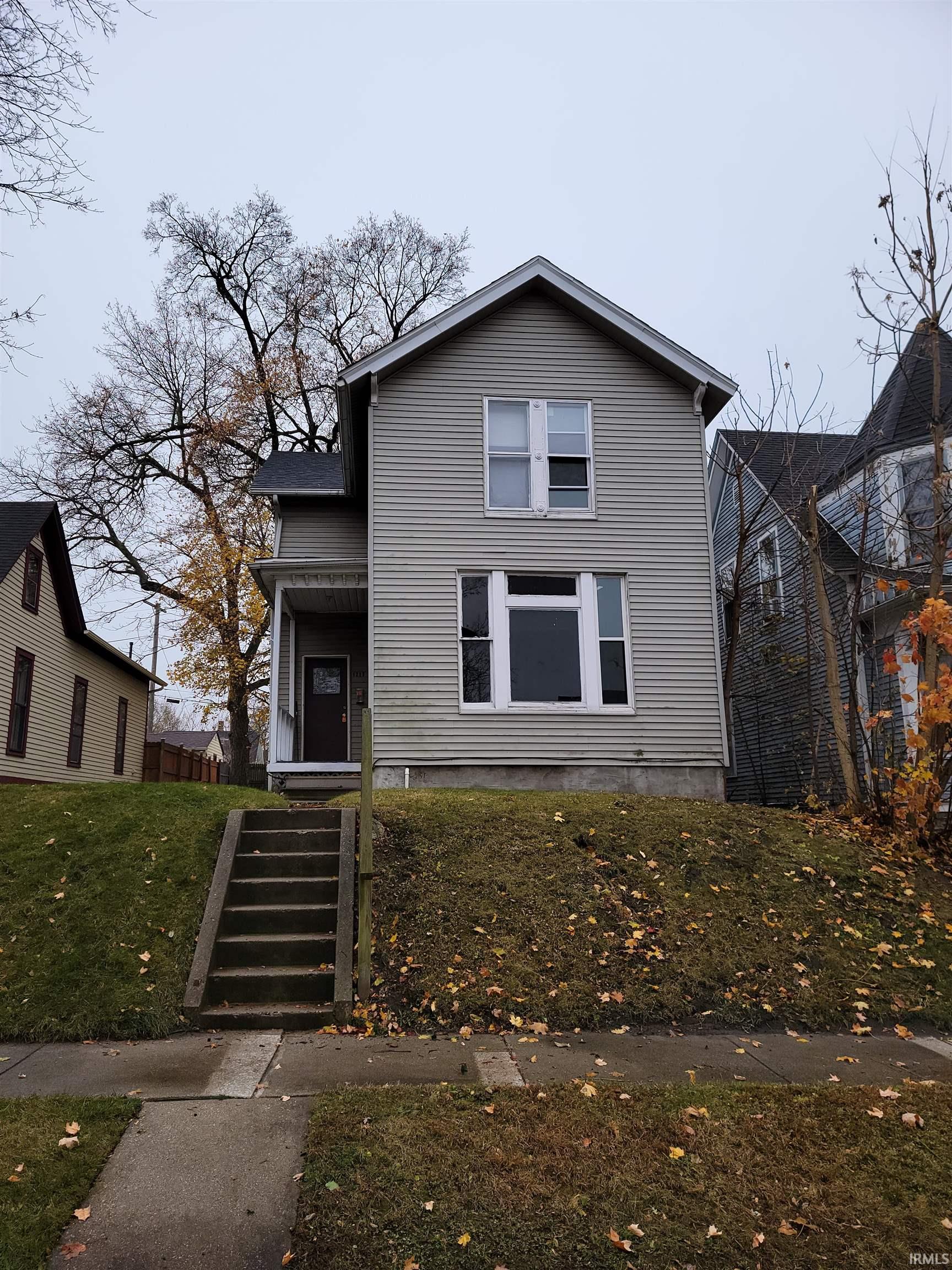 Traditional-style house with a front yard and a porch