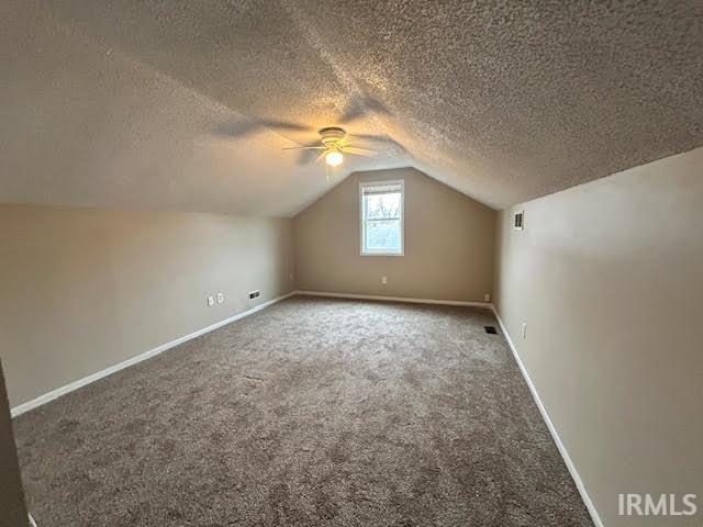 Bonus room with a ceiling fan, carpet flooring, and a textured ceiling