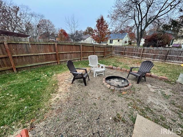 Fenced backyard with an outdoor fire pit and a patio