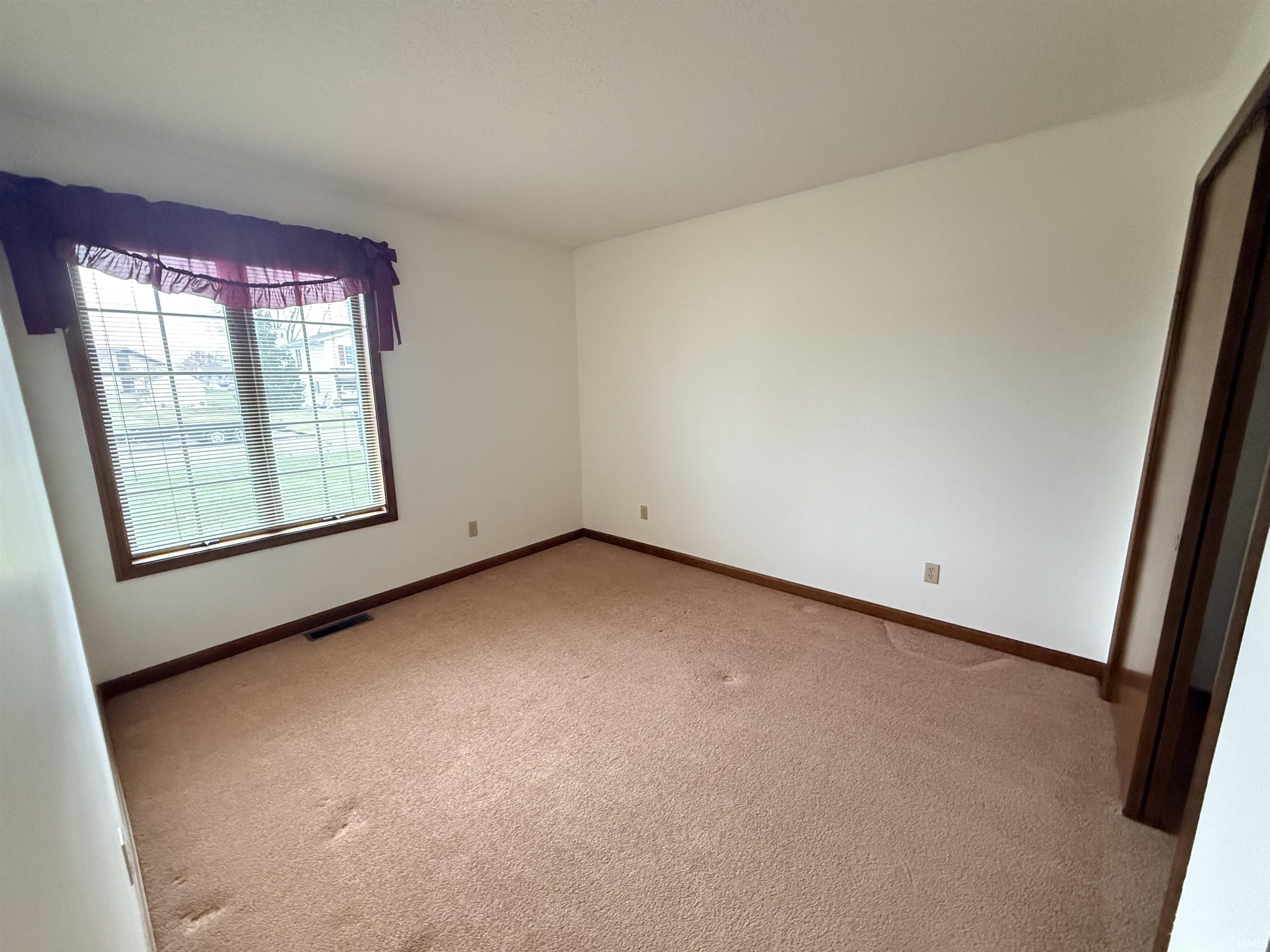 Carpeted spare room with baseboards